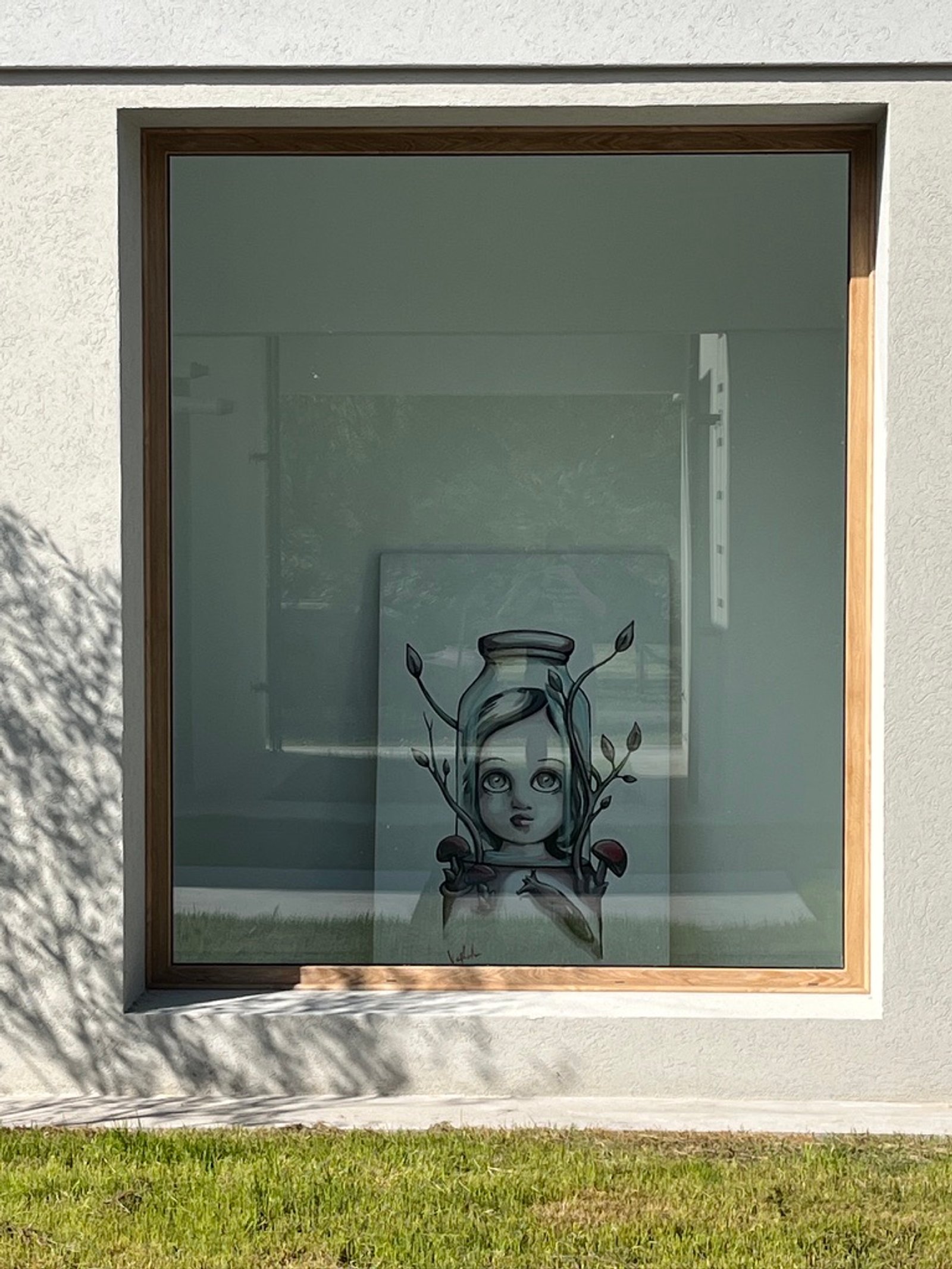 Fachada moderna con ventana grande y obra de arte interior — proyecto La Colina, por Arcucci Arquitectura, en La Colina Villa de Campo