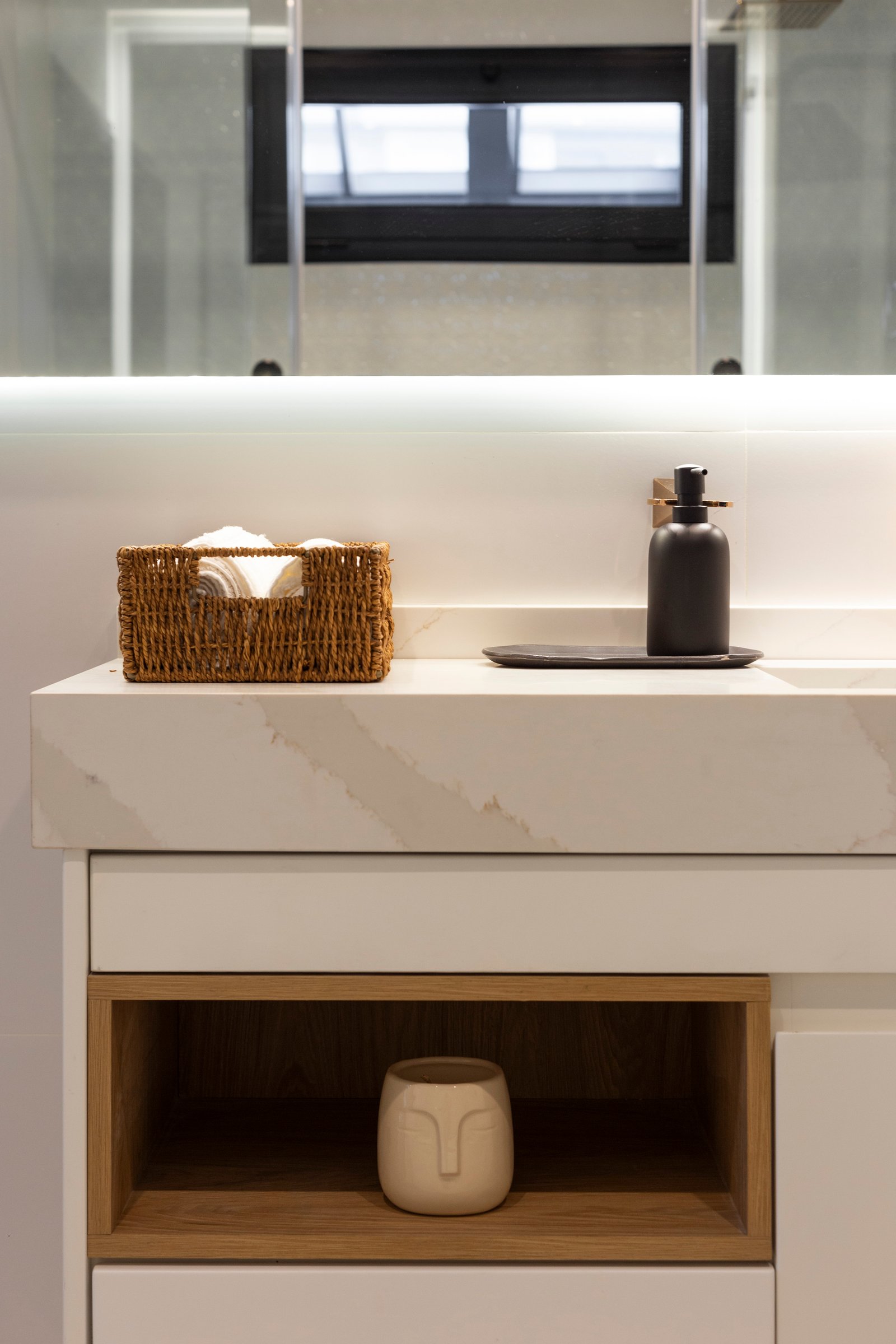 Baño moderno con detalles en mimbre y cerámica con forma de cara — proyecto JURAMENTO, por Nima Estudio, en Buenos Aires