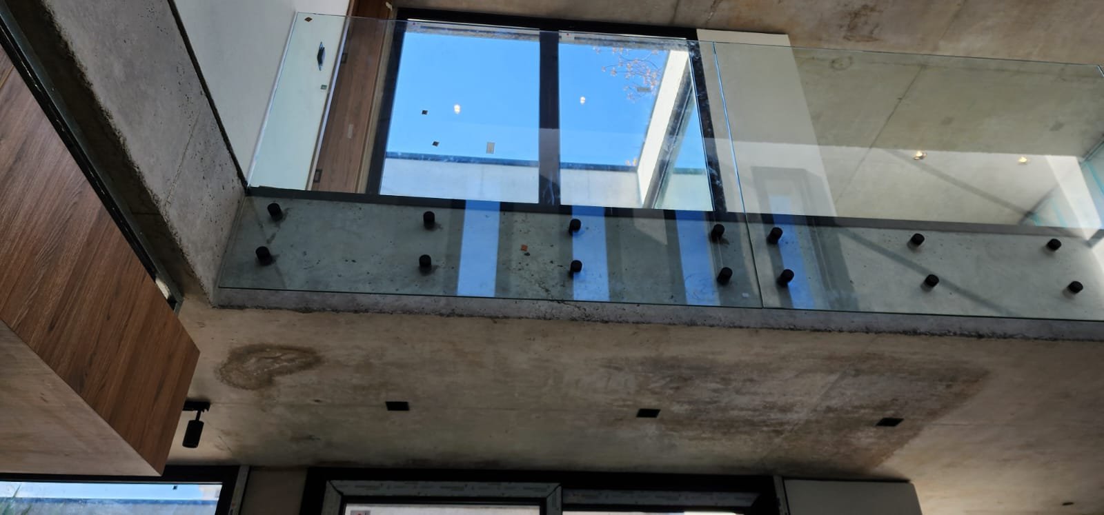  detalhe arquitetônico moderno em construção com concreto e vidro — projeto Barandas templadas, por Cristalcenter, em Pilar
