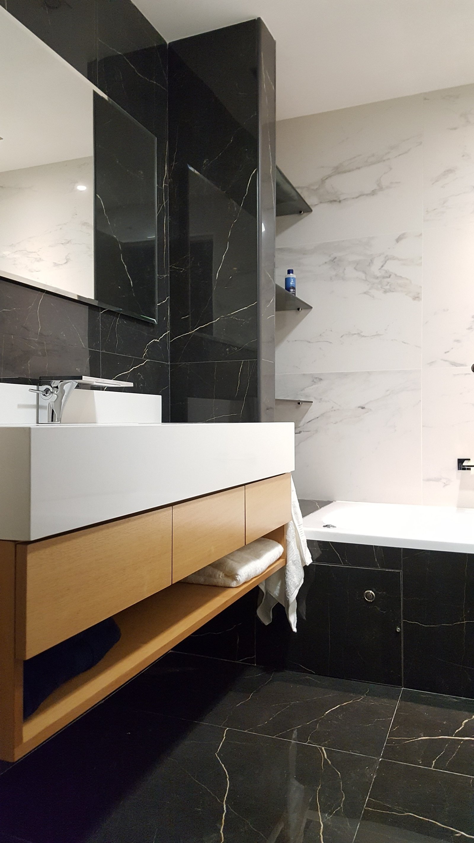 Baño moderno con vanitory flotante y mármol blanco y negro — proyecto Reforma PP, por Monarq Arquitectura, en Puerto Madero