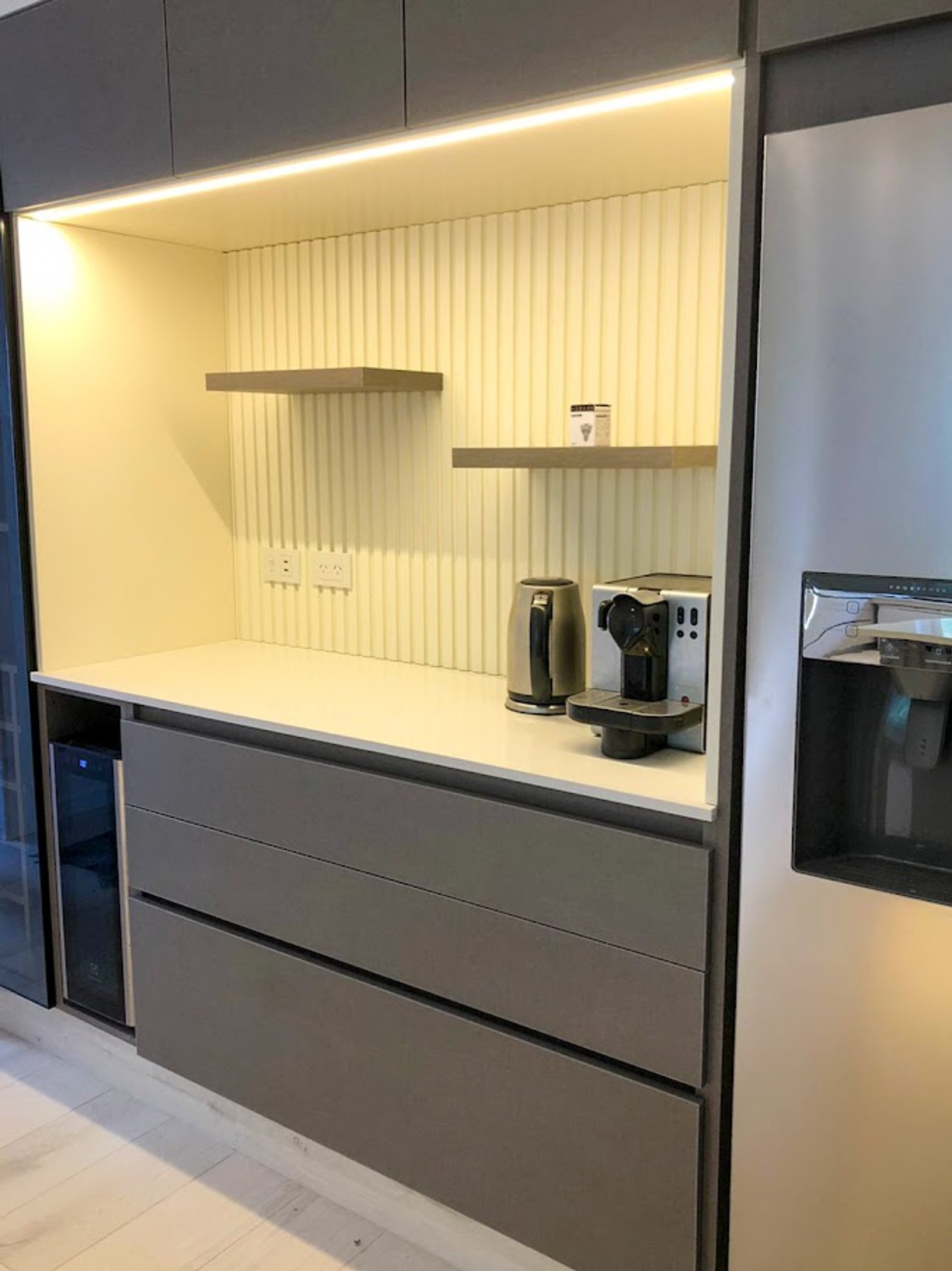 Cocina moderna con muebles grises, estantes flotantes e iluminación indirecta — proyecto Línea Roma, por Casa Leiro