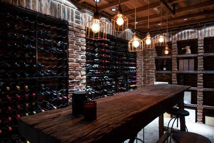 Bodega de vinos con paredes de ladrillo visto y mesa madera robusta — proyecto Casa Toscana , por Estudio Du 