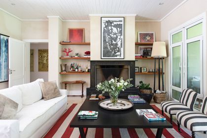 living moderno con hogar central, sofá blanco y muebles rayas negras — proyecto La Chacra , por Estudio Du 