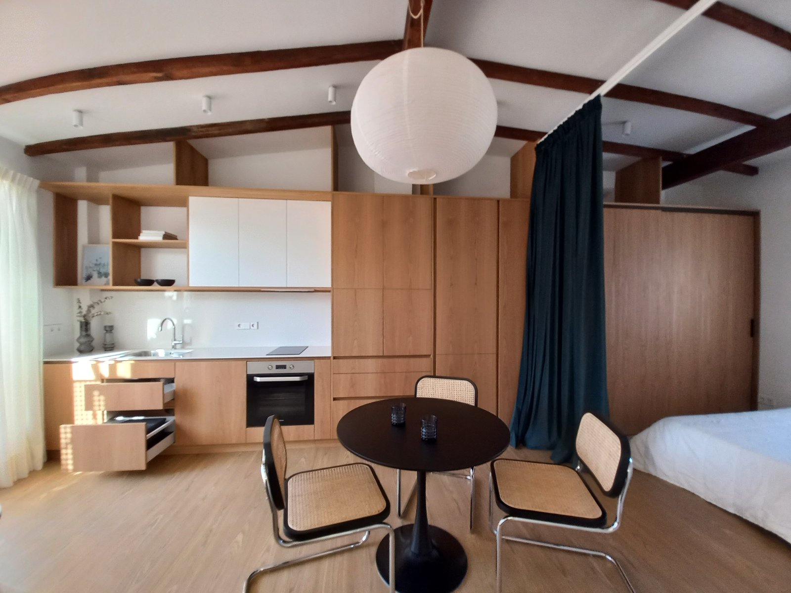 Cozinha moderna integrada com ilha e grande lustre esférico — projeto Burriana, por JT ARQUITECTURA, em Valencia
