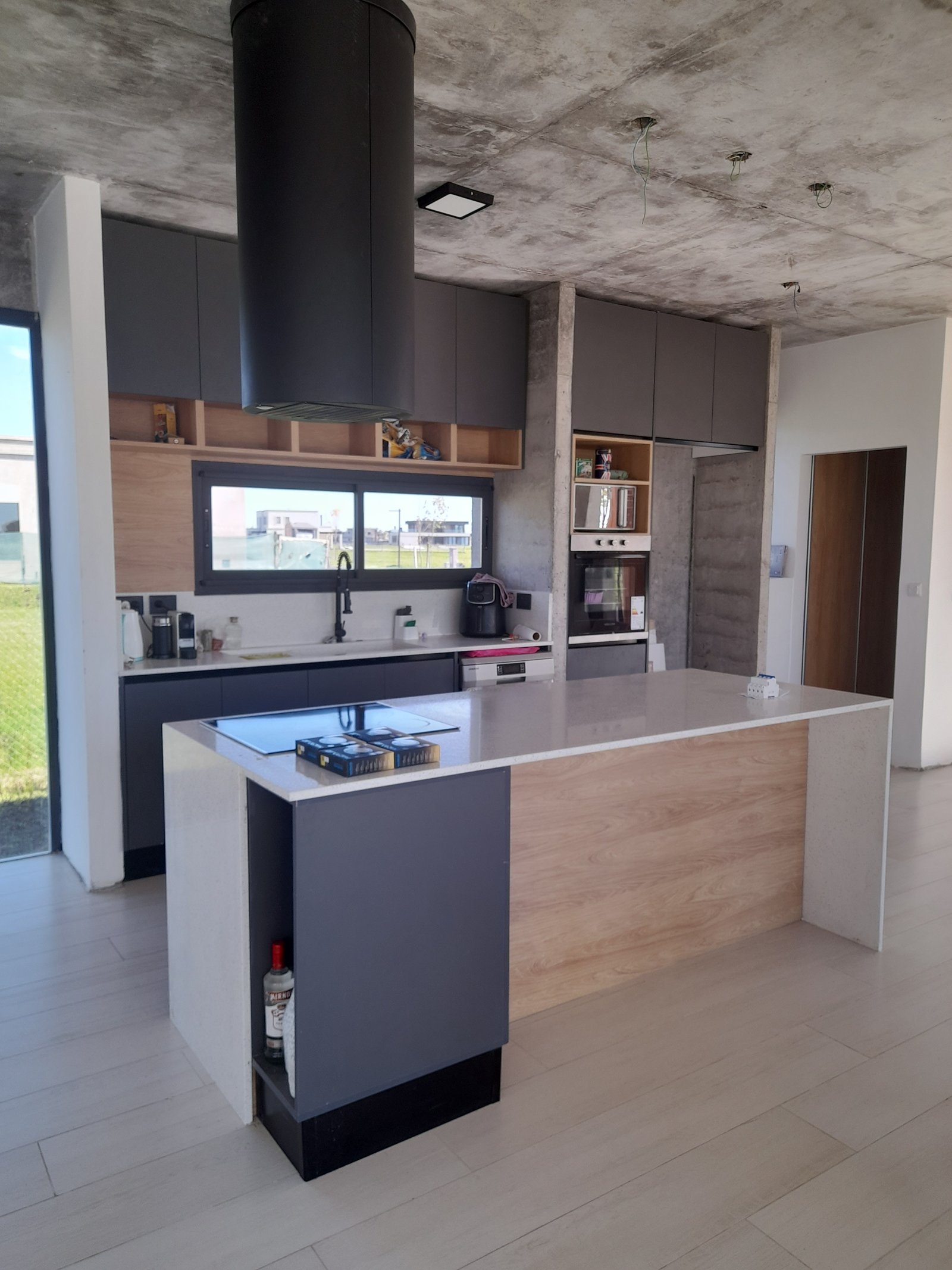 Cocina moderna con isla, techos de hormigón expuesto y gabinetes grises — proyecto Puerto Nizuc, por Estudio Fernandez Long & asoc., en Au Dr. Ricardo Balbín km 31.5