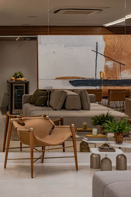 Living contemporáneo con sillón cuero, sofá gris y obra abstracta — proyecto APTO UNIQUE, por Juliana Frota Arquitetura, en Adrianópolis
