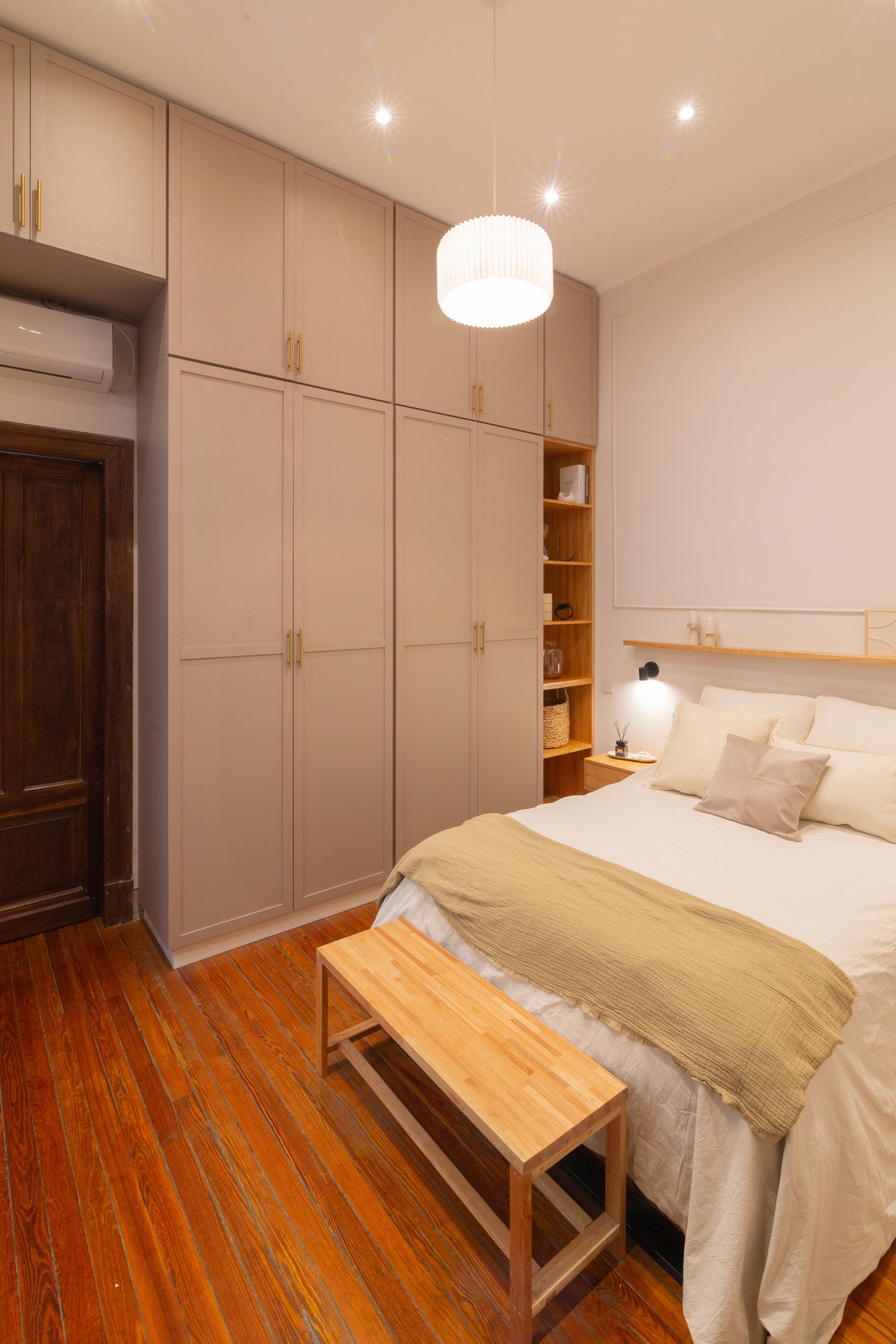Dormitorio moderno con armarios empotrados y luz cálida — proyecto Anchorena, por Martina Kleinert, en Palermo