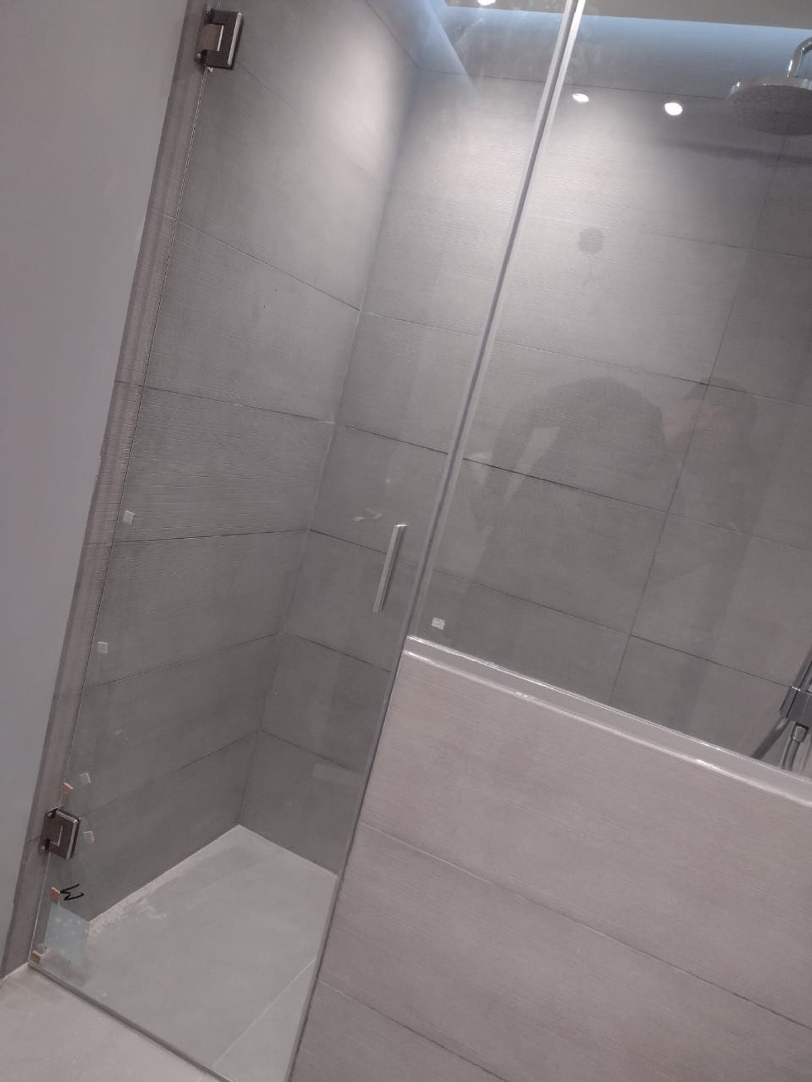 Baño moderno con ducha de vidrio y revestimiento gris — proyecto Mamparas varias , por Cristalcenter, en San Vicente