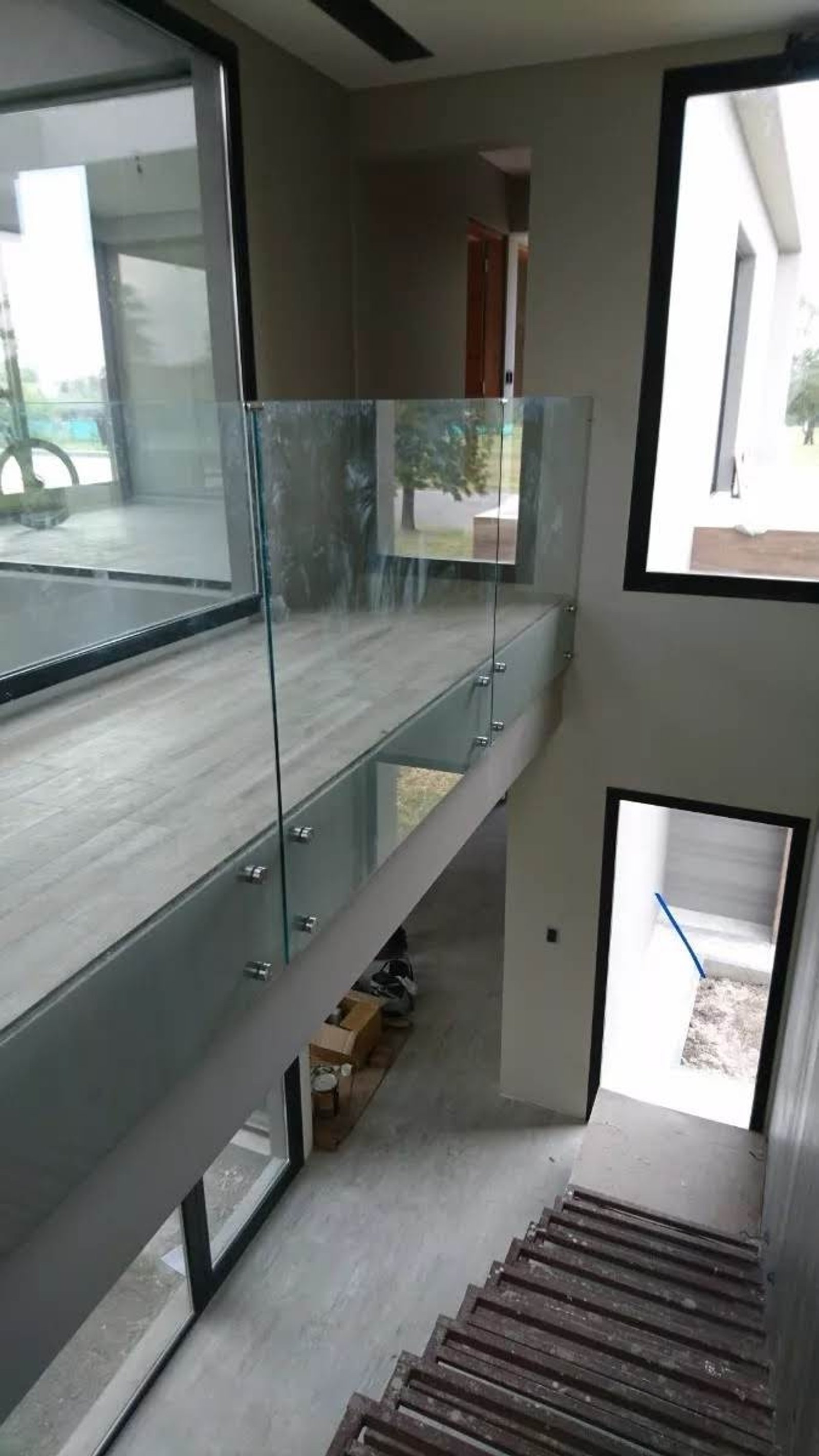 moderno pasillo con escalera de cristal y madera — proyecto Baranda 10 mm incoloro templada con botones 38mm acero, por Cristalcenter, en Belén de Escobar