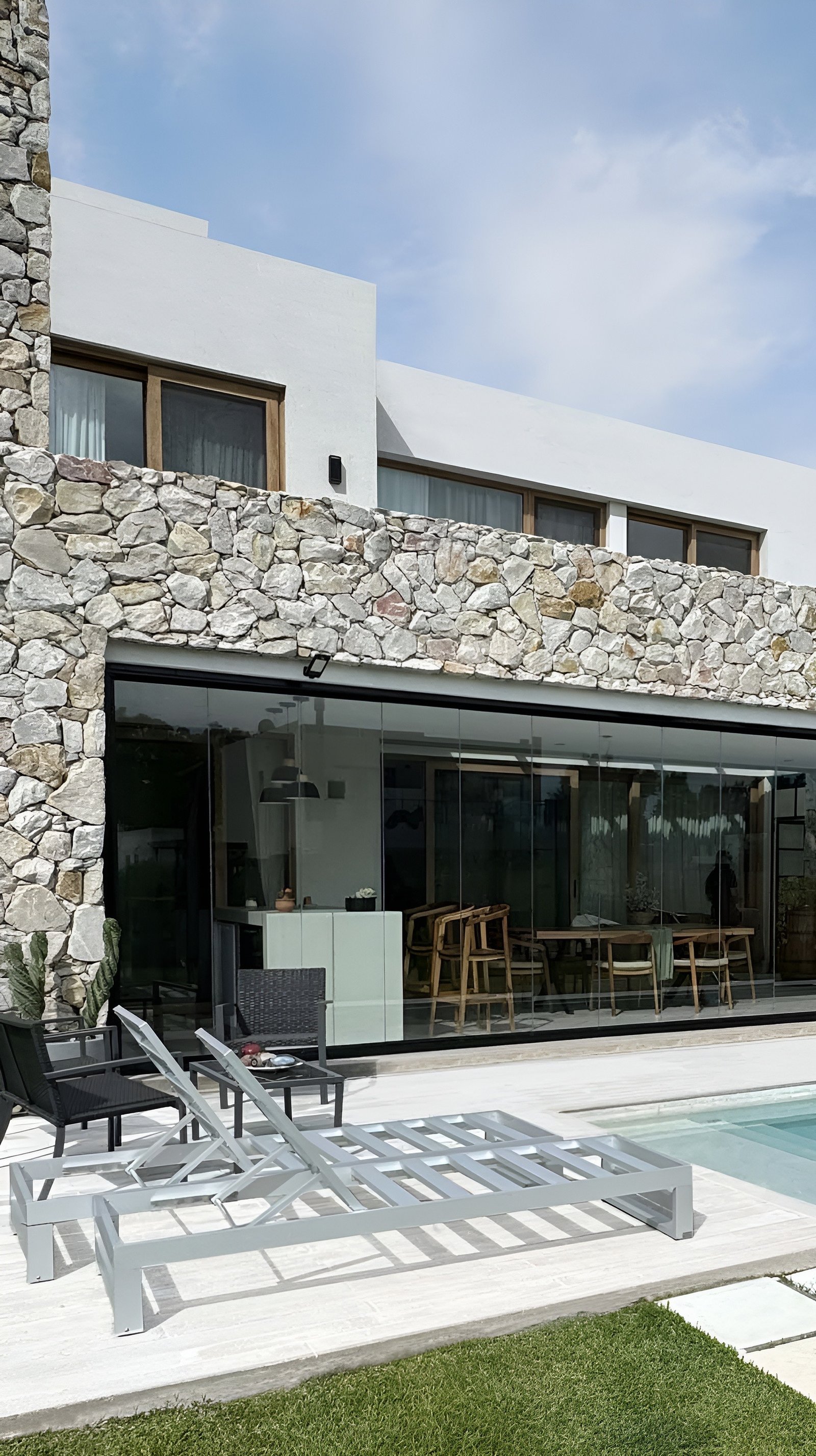 Casa moderna de piedra y vidrio con piscina y amplios ventanales — proyecto Casa ER , por Hermann Arquitectos, en Arribeños 1611