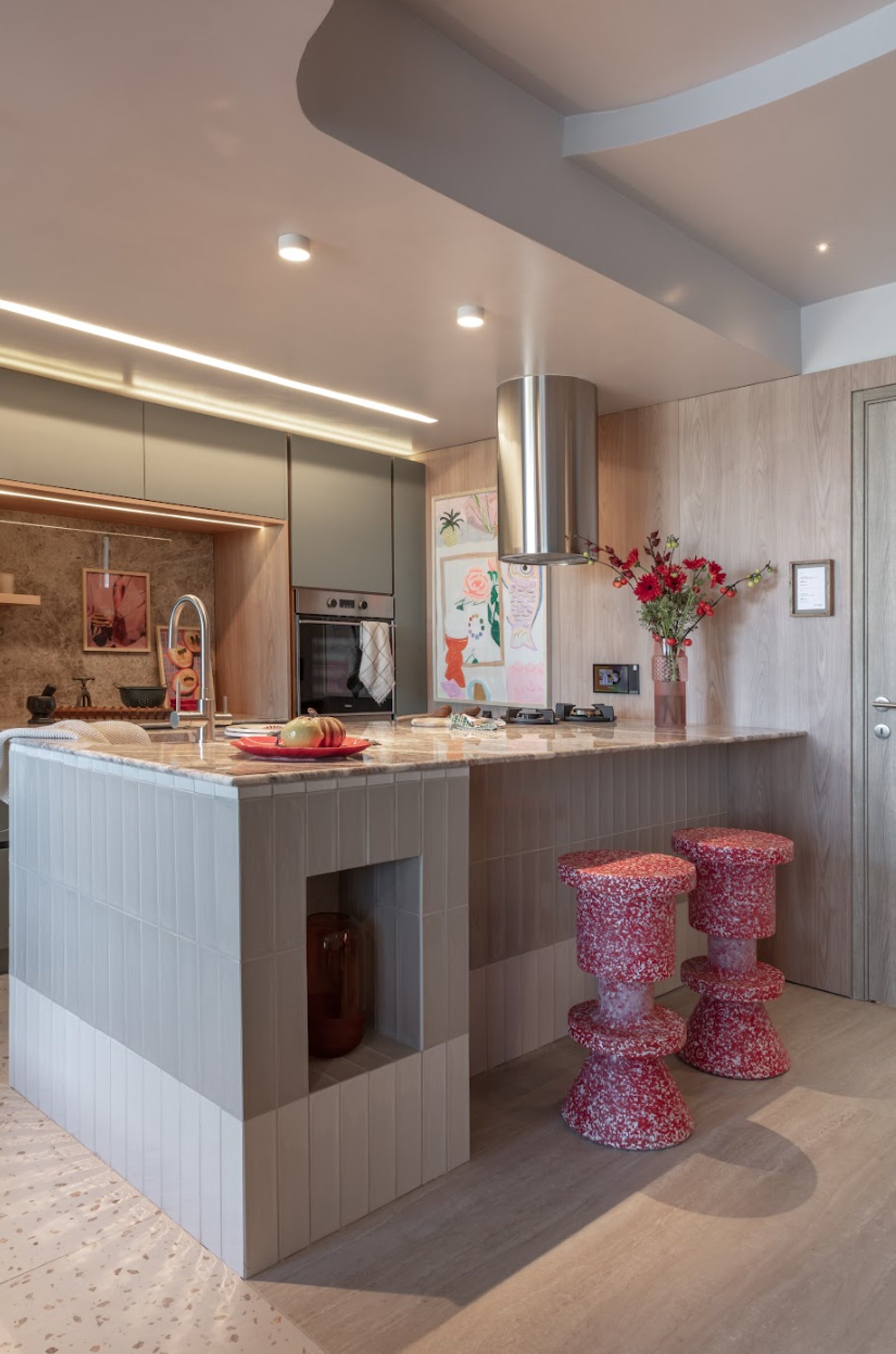Cozinha moderna aberta com ilha e bancos esculturais vermelhos — projeto Sara Plazibat, por San Lorenzo Design, em Cam. de los Remeros 1585