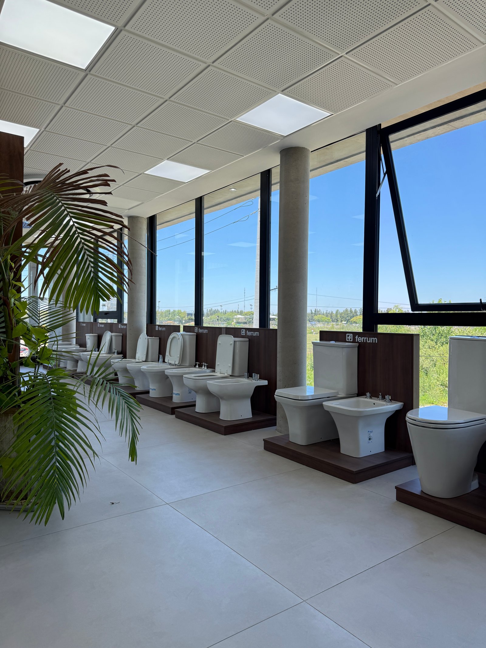 Exhibición de inodoros modernos con luz natural y plantas — proyecto Showroom, por GAP HAUS, en Calle Austria Nte. 2450