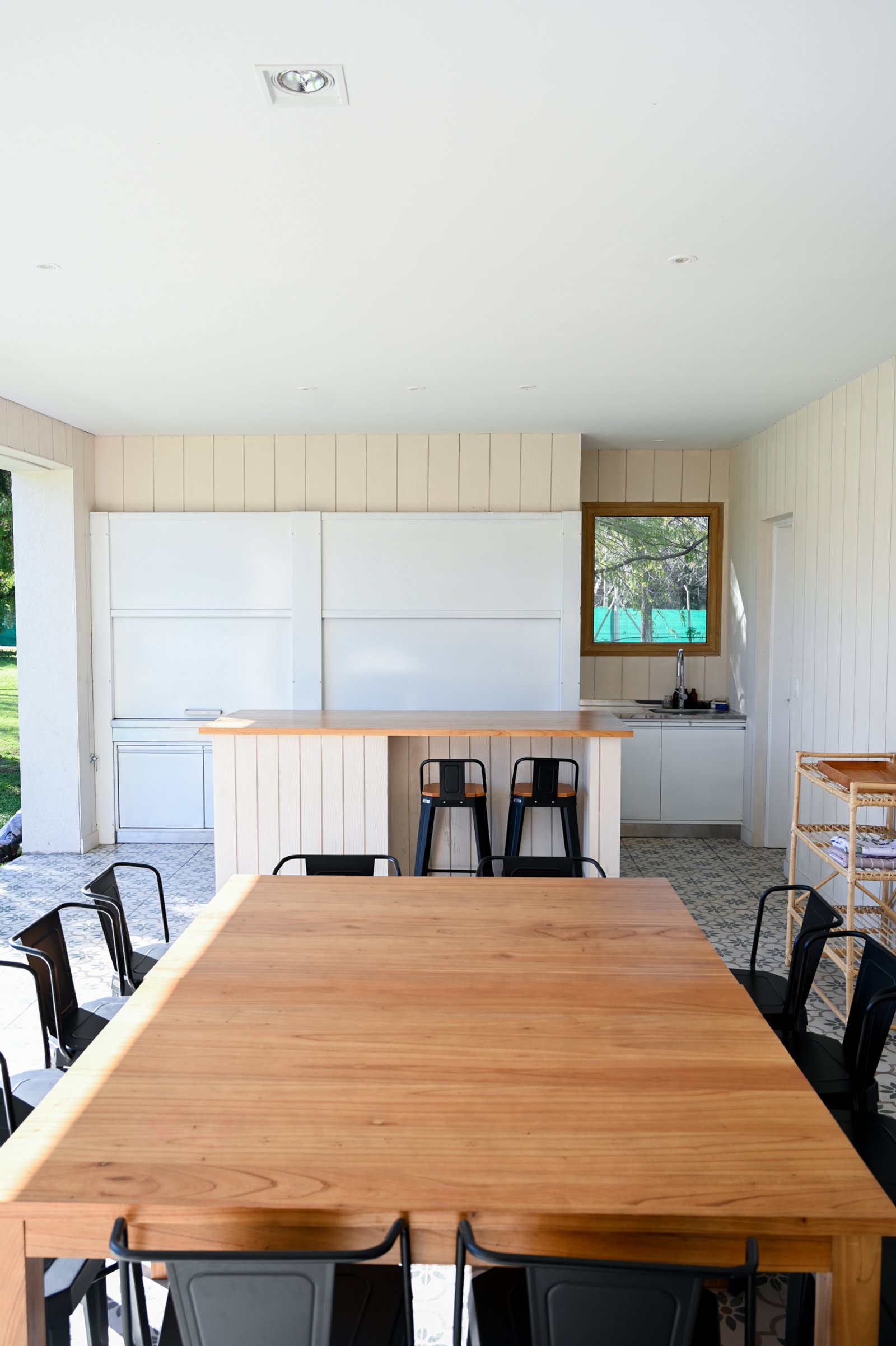 Comedor y cocina moderna con isla, mesa de madera y sillas industriales — proyecto Galeria, por CASA1-TROMEN, en Bella Vista