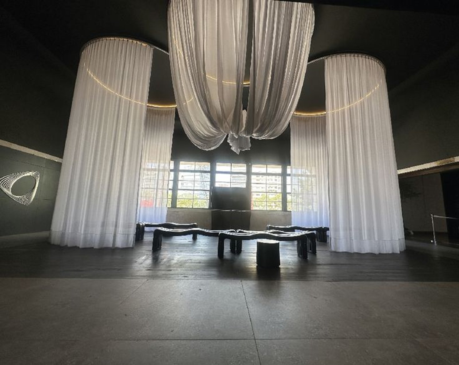 Espaço comercial moderno com cortinas dramáticas e móveis orgânicos — projeto Casa Foa Parque de la Innovación, por Vite Porcellanato, em Buenos Aires