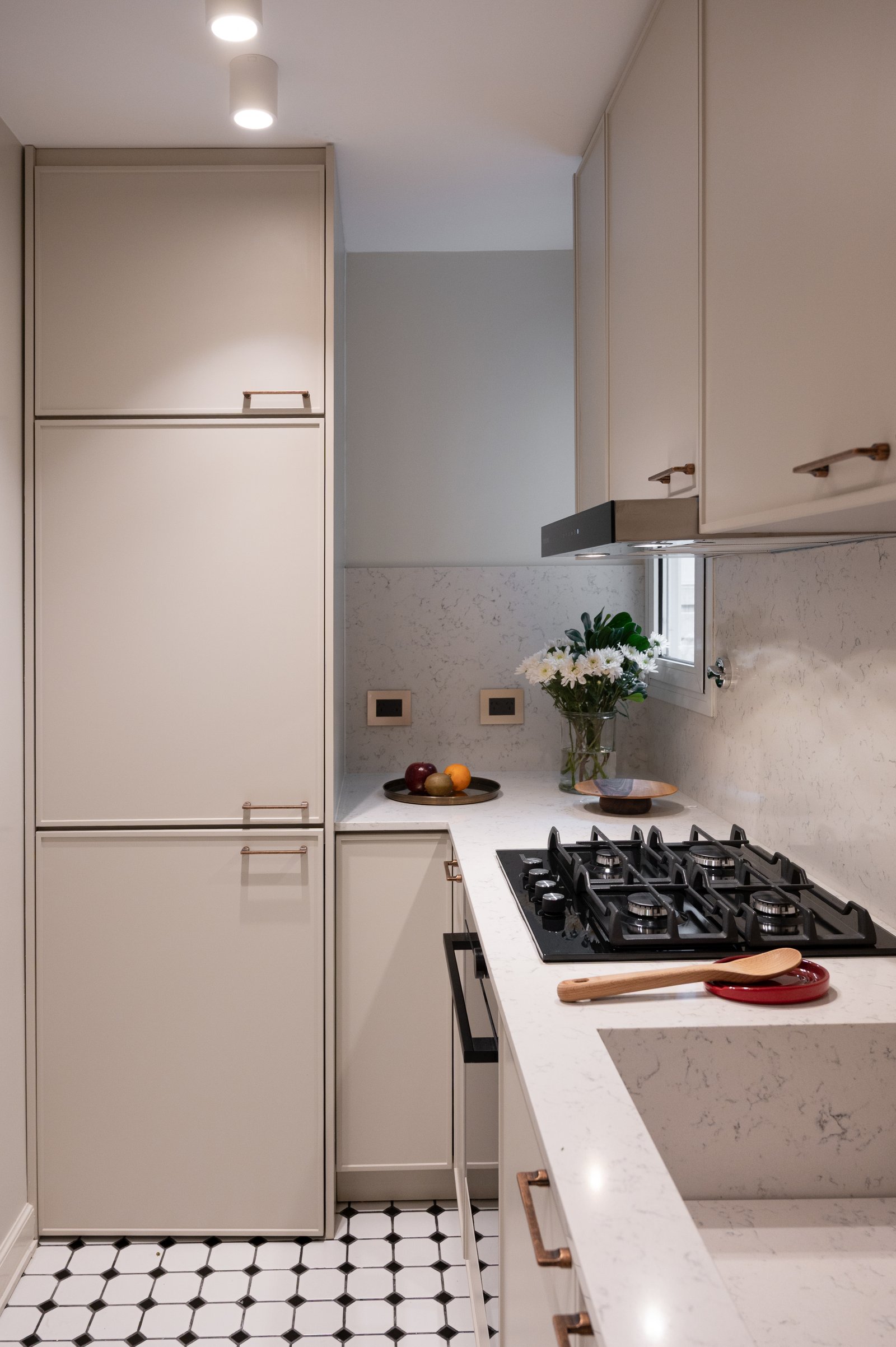 Cocina moderna L con muebles beige, mesada de piedra blanca y piso damero — proyecto LIBERTADOR DANDY, por AB ARQUITECTURA, en Recoleta