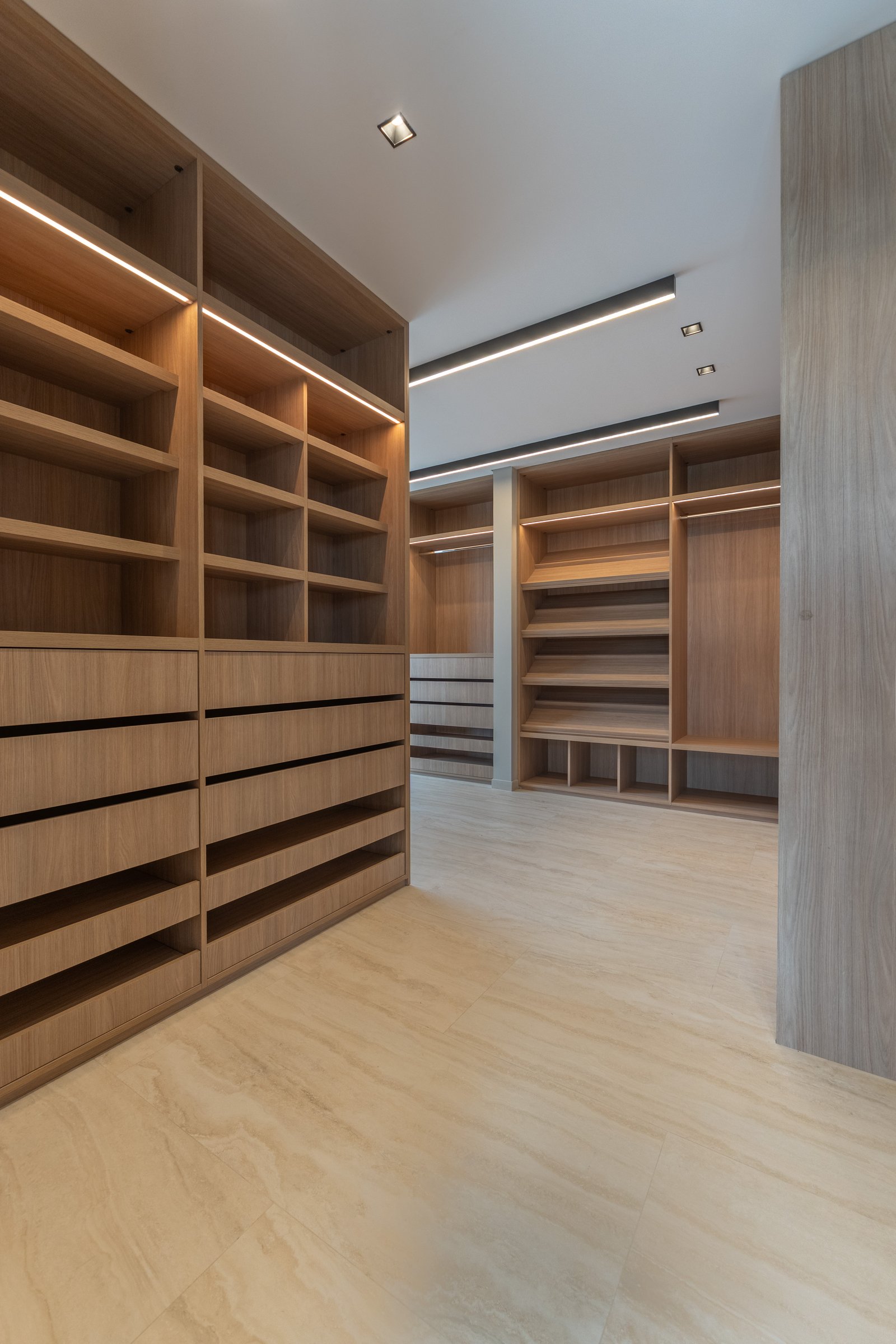 Amplio vestidor moderno con carpintería de madera y luz integrada — proyecto Yacht - Estudio CCWay, por ABEJA CONCEPT, en Av. de la Ribera 560