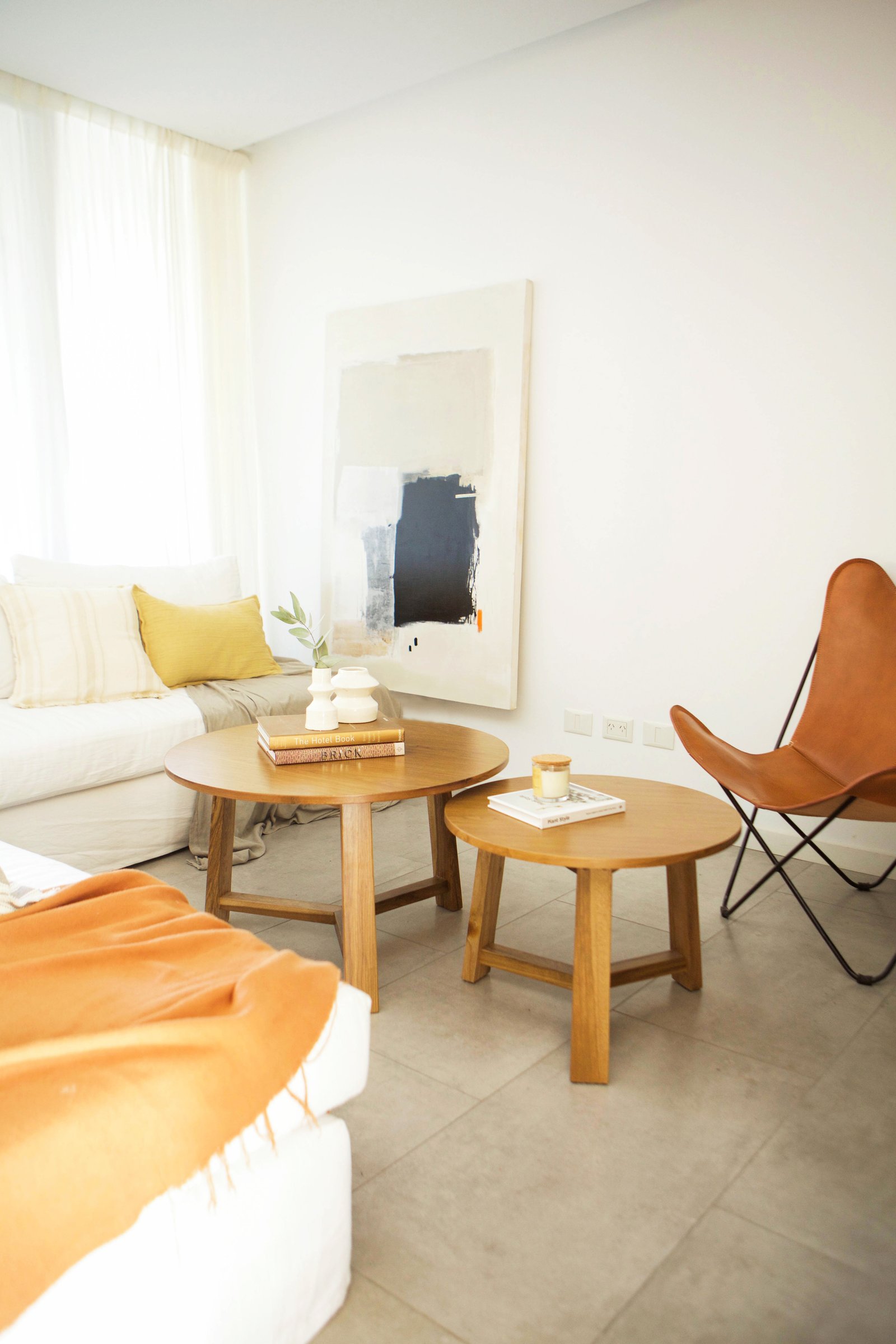 Living moderno con sofá blanco, sillón mariposa y mesas de madera — proyecto Javo, por LACROZE DESIGN STUDIO, en San Isidro