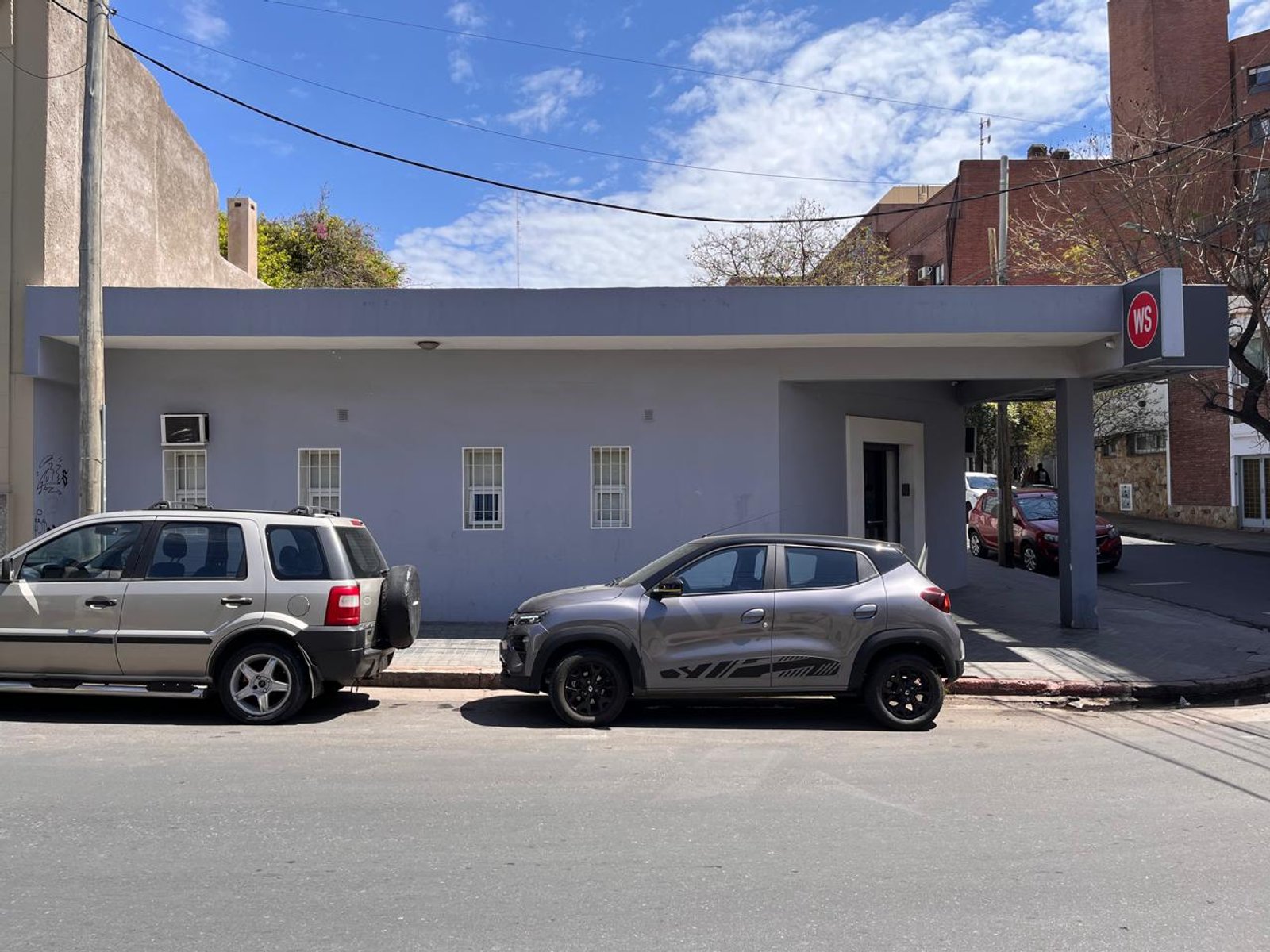 fachada de local comercial moderno con autos estacionados — proyecto FACHADA WARNING, por Todo con A, en Córdoba