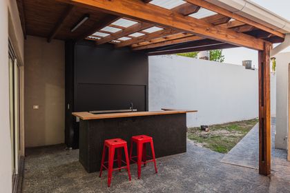 Quincho moderno con parrilla de hormigón y pérgola de madera — proyecto Remodelacion en Villa de Mayo, por MSMC, en Villa de Mayo