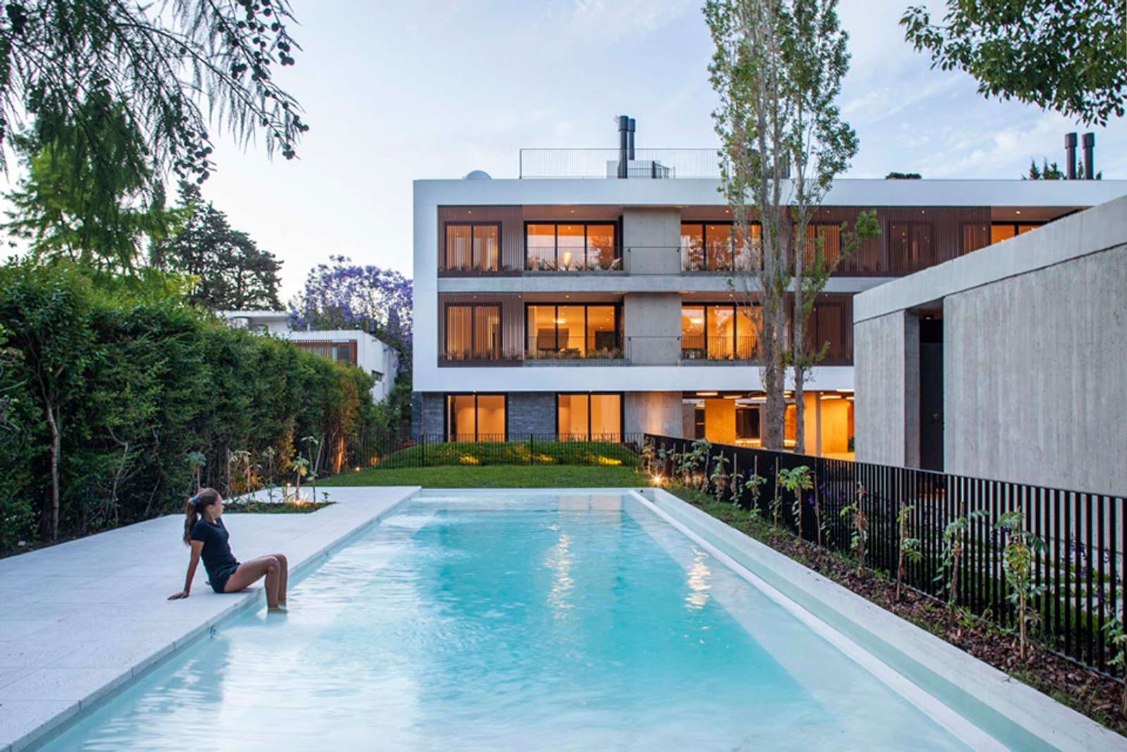 pileta moderna con fachada minimalista y vegetación — proyecto Alvear AV, por MUCHTEK, en La Plata