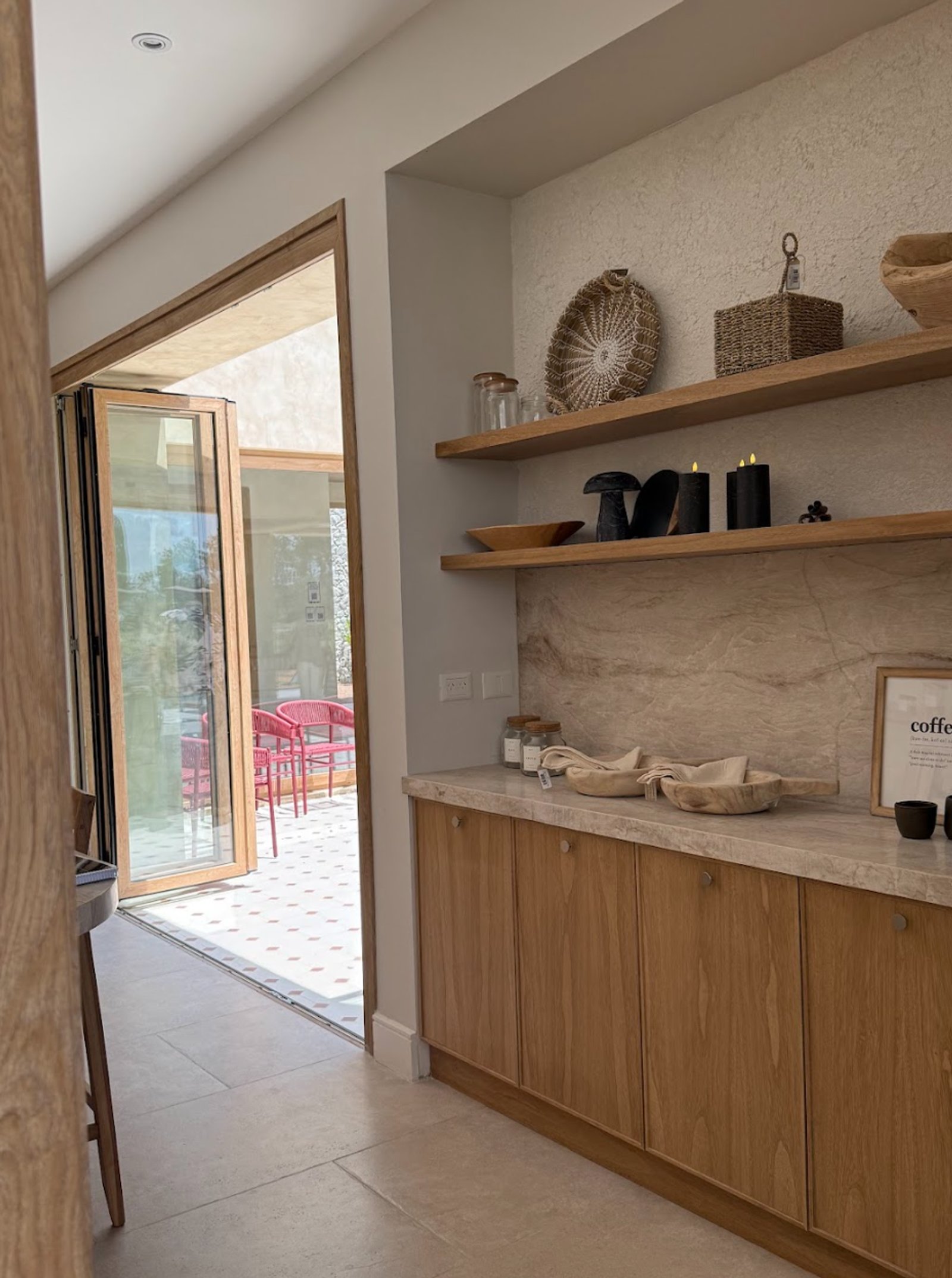 Cozinha moderna com portas de vidro dobráveis e móveis de madeira clara — projeto La Verbena, por Grupo Pauta Arquitectura, em Alejandro Korn 3150