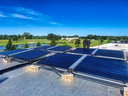 Paneles solares térmicos en terraza con vista a campo verde — proyecto Panel Solar - Haras Santa Maria, por Climatizacion HD, en Belén de Escobar