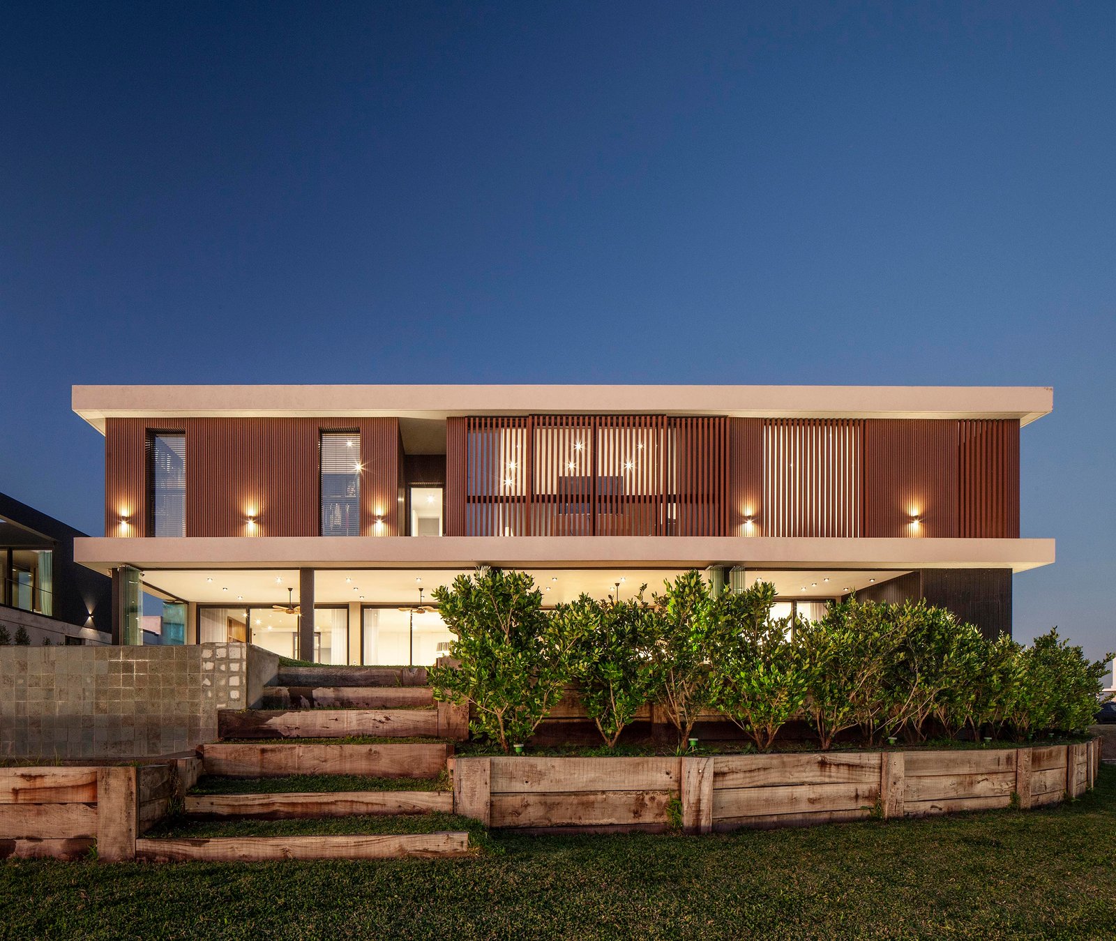 fachada moderna com madeira escura e grandes janelas — projeto CASA C313, por A'PRIMA - Arquitectura Sustentable, em Provincia de Buenos Aires