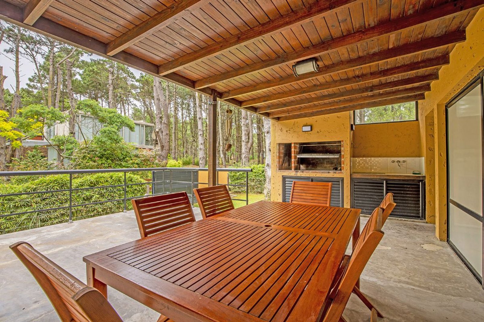 Comedor exterior con parrilla, mesa de madera y pérgola — proyecto LA  ALHAMBRA, por GJF estudio, en Costa del Este