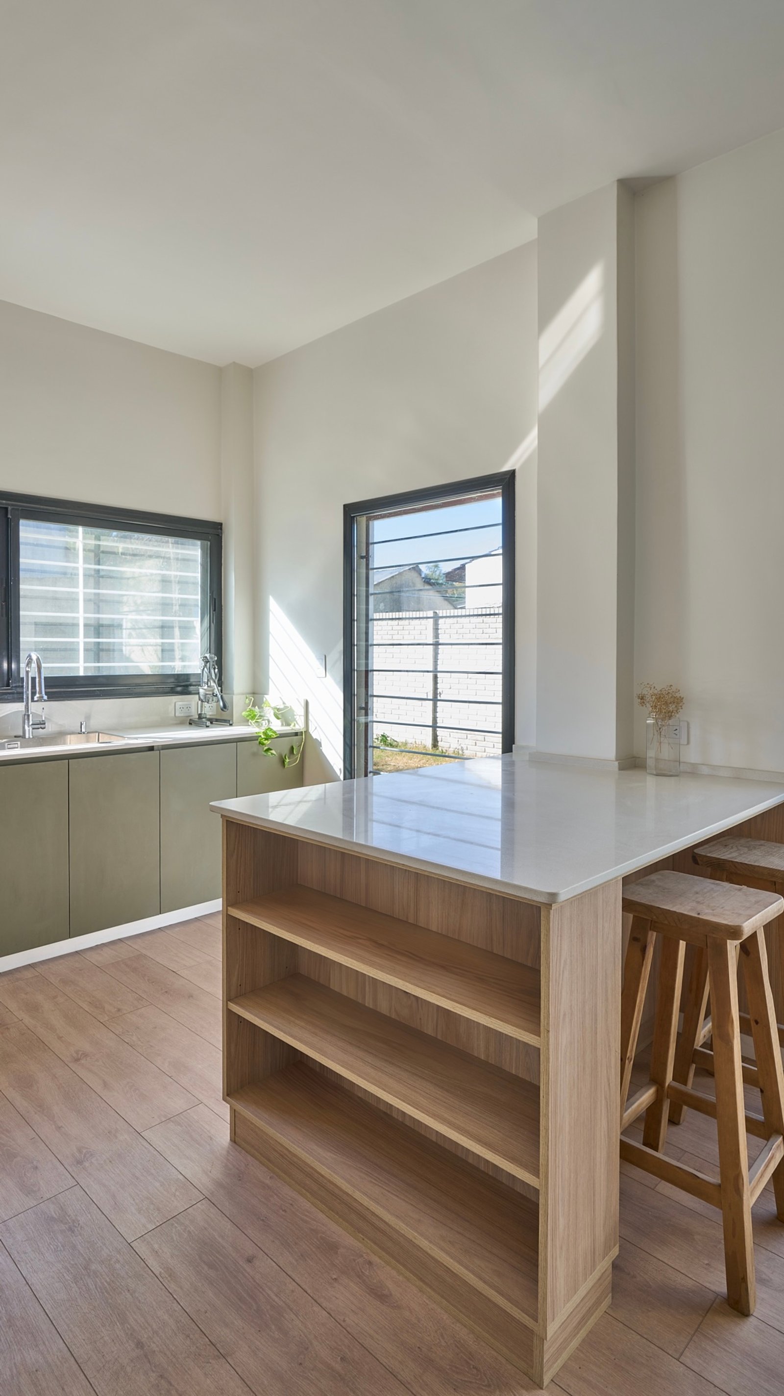 Cocina moderna con isla, luz natural y pisos de madera — proyecto Granville, por Baler.Gelbert Arquitectura, en B1845 José Marmol