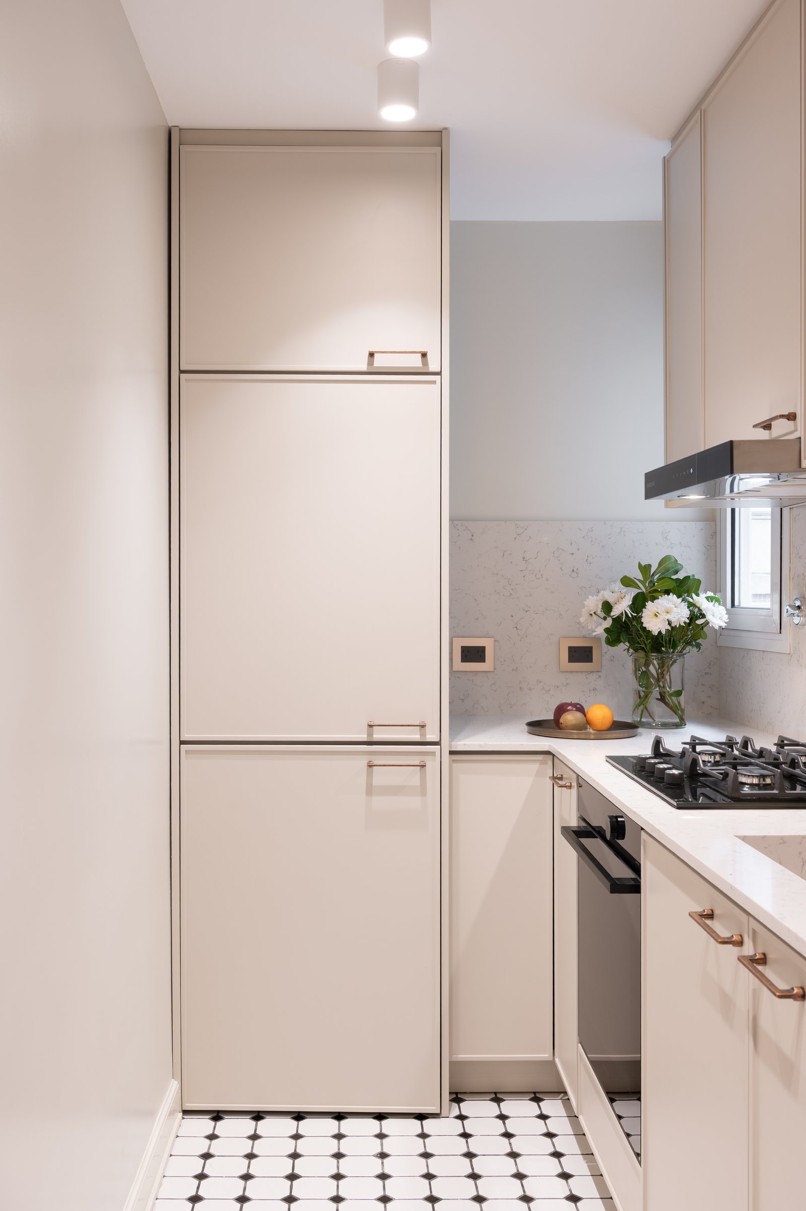 Cocina estrecha con muebles altos beige y cocina a gas — proyecto LIBERTADOR DANDY, por AB ARQUITECTURA, en Recoleta