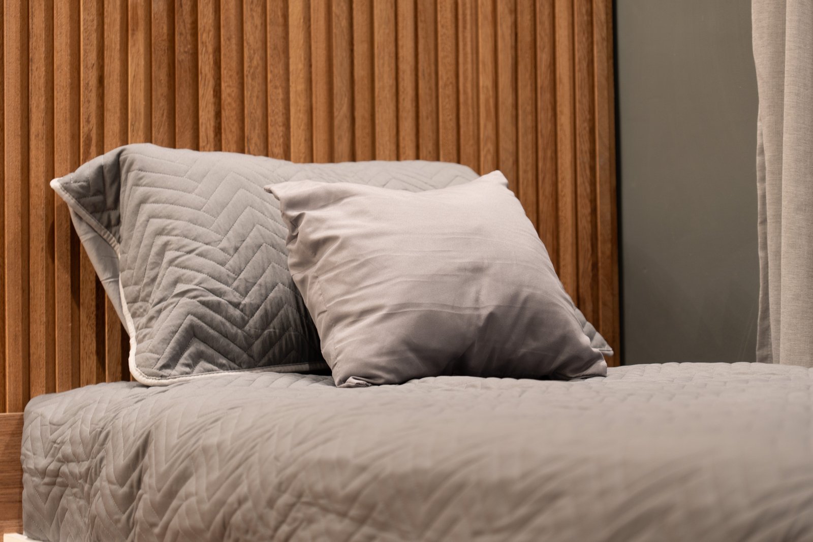 quarto com parede de ripas de madeira e cama cinza — projeto Dormitorio  Palermo, por HEIM ARQUITECTURA INTERIOR, em Palermo Hollywood