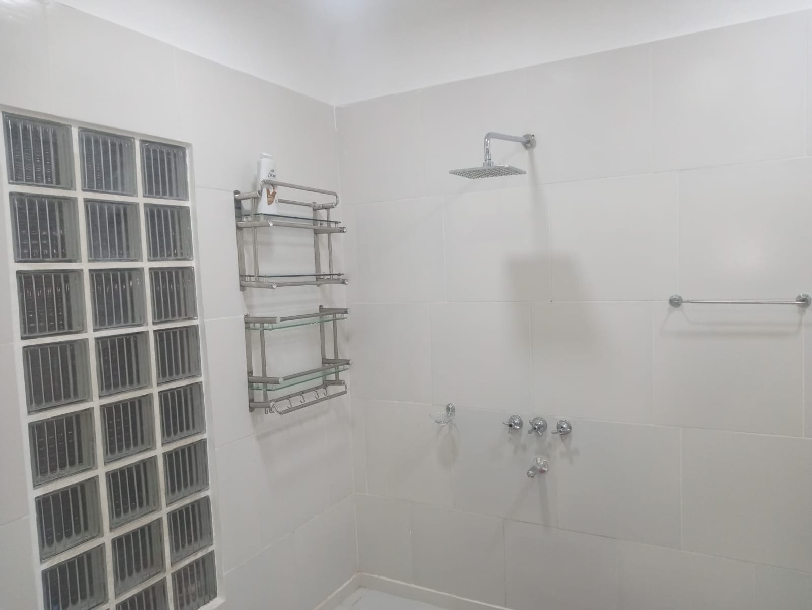 Baño con ducha, estantería metálica y azulejos blancos — proyecto Esmeralda 517, por A&E construcciónes, en Esmeralda 517