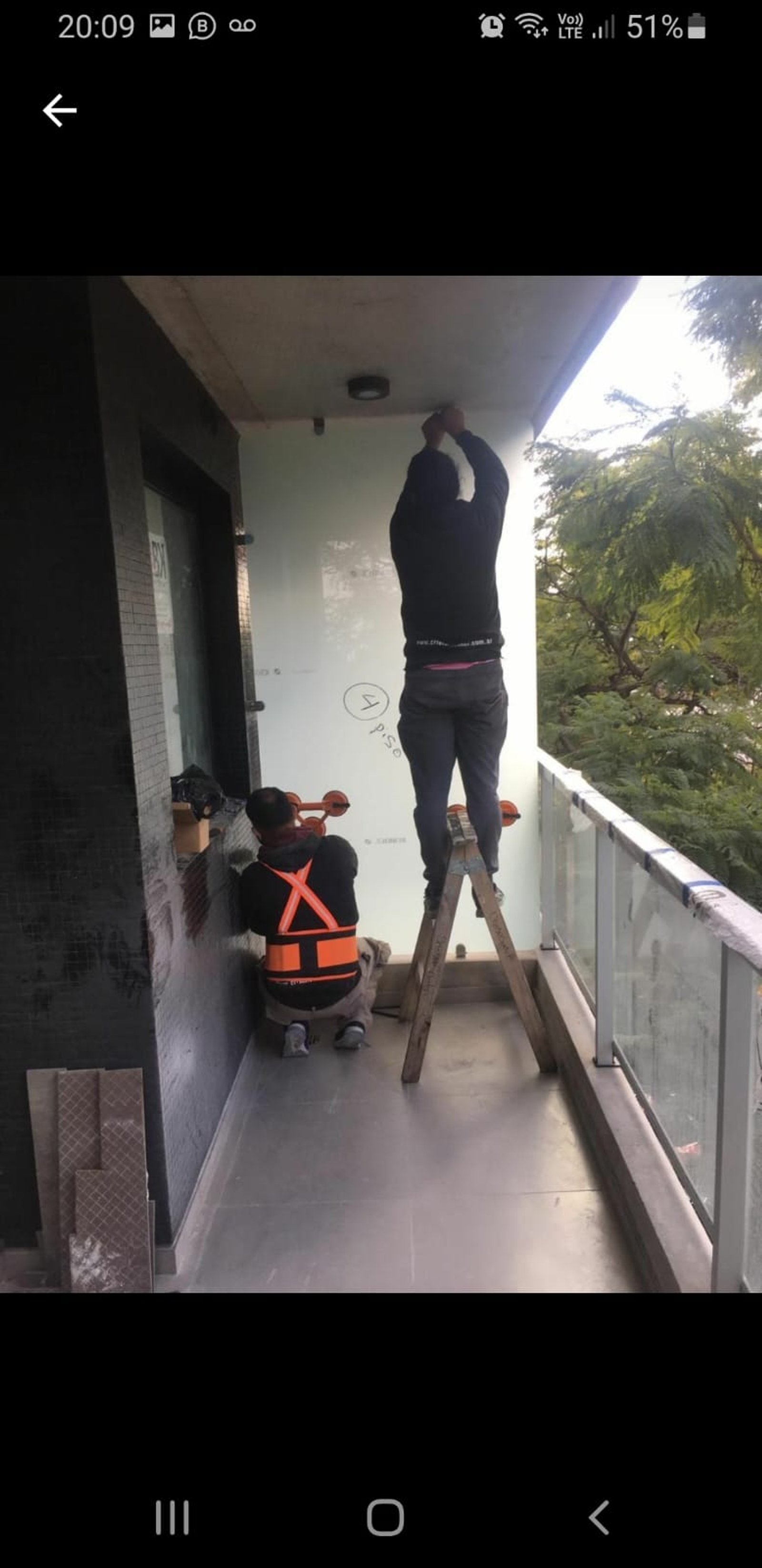 Instalación de panel de vidrio en balcón con obreros — proyecto Divisores balcon laminado Blindex esmerilados 5+5, por Cristalcenter, en Villa Devoto