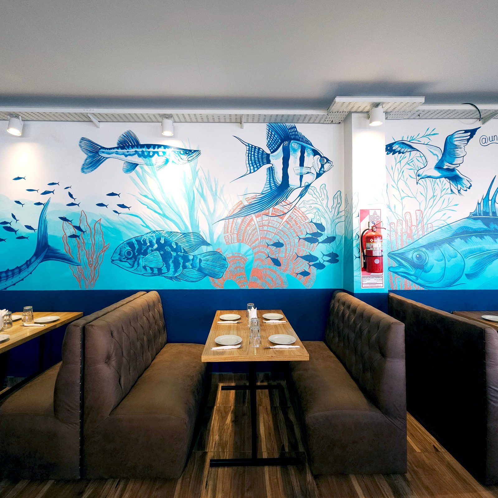 Comedor moderno con mural de peces y asientos curvos — proyecto Chicha cocina peruana., por UN.MURAL, en Comisionado José Indart 2699