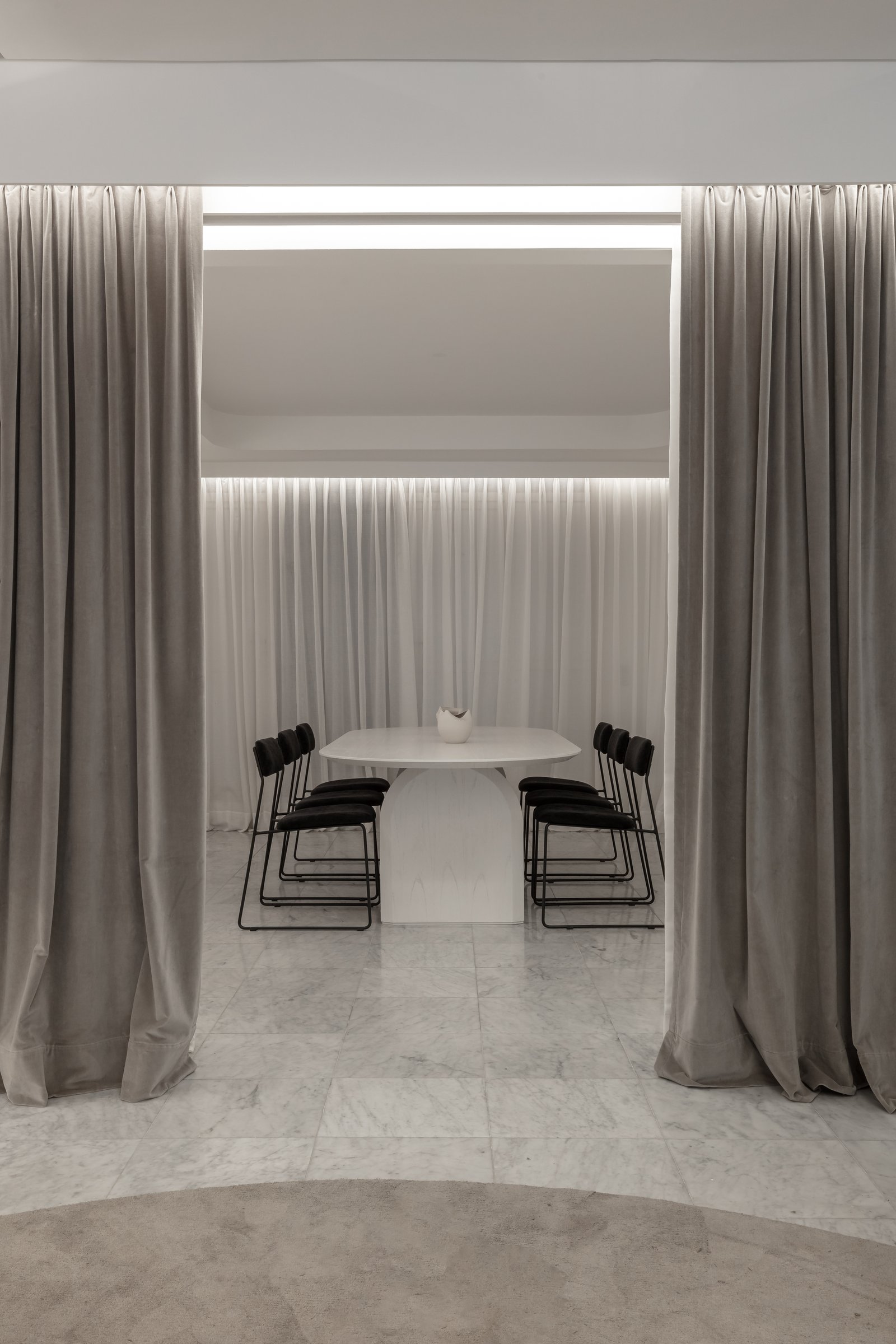 Comedor minimalista con cortinas dramáticas y mesa oval — proyecto Figueroa Alcorta | Rhinoplasty meets art, por Ren Studio, en Palermo Chico