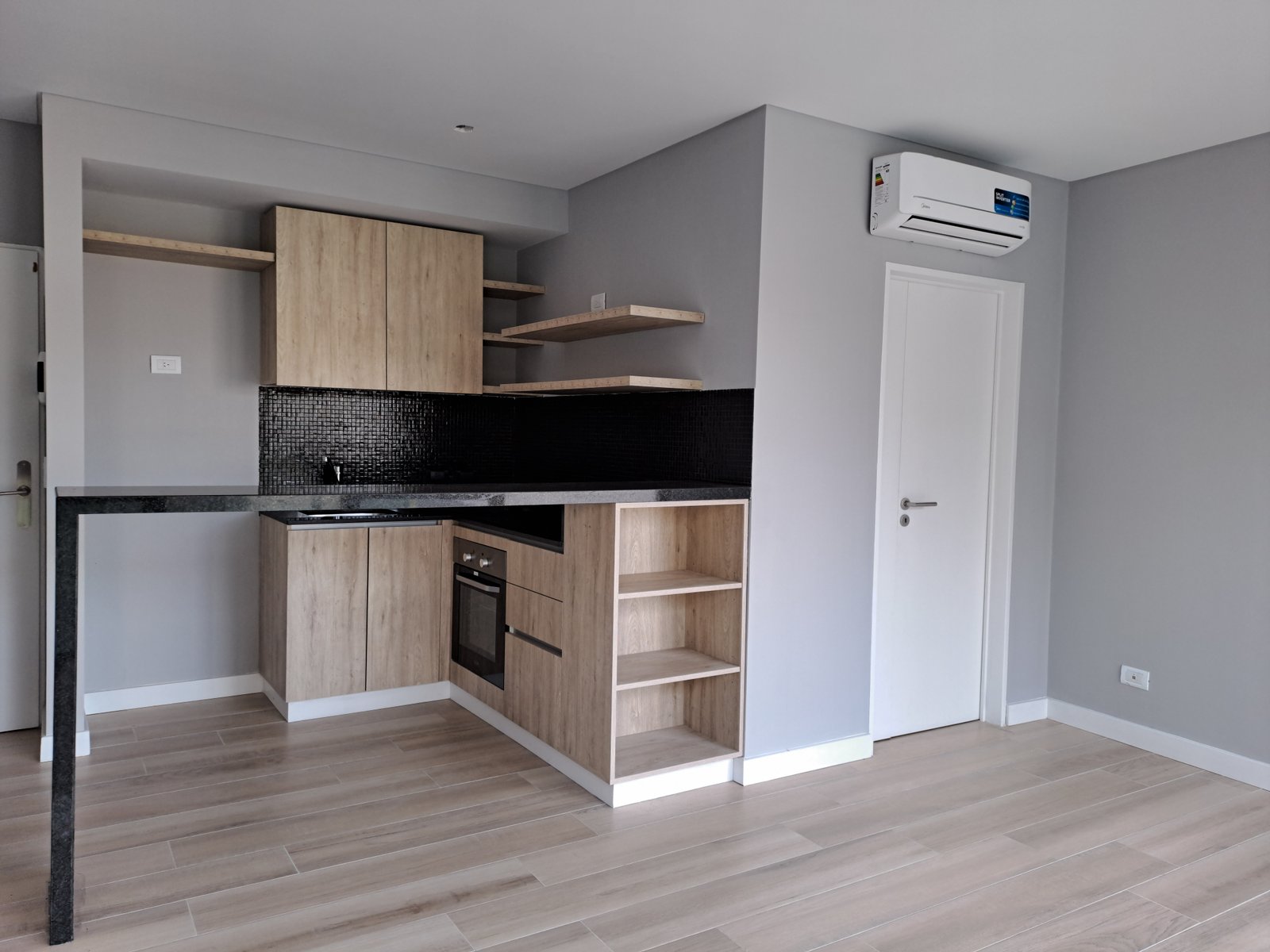 Cocina integrada moderna con muebles de madera y paredes grises — proyecto Edificio Aranguren, por LW Lopez Wolder arquitectos, en C. Dr. Juan Felipe Aranguren 1536