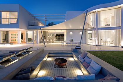 Patio moderno con fogonero, sillon bajo y toldo de tela — proyecto OX8 - Casa en Martindale, por MLS Estudio, en Martindale Country Club
