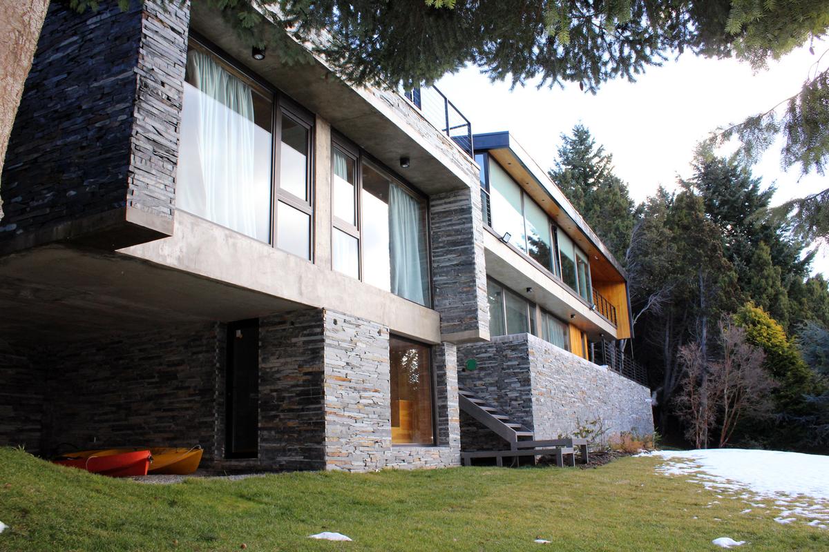 Casa moderna de pedra e vidro em ambiente de montanha — projeto Casa Península San Pedro, por Servente Larrazabal Arq, em Bariloche