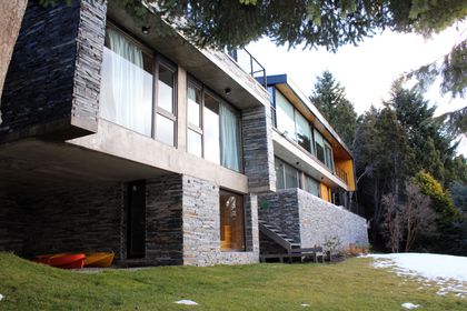 Casa moderna de piedra y cristal en entorno de montaña — proyecto Casa Península San Pedro, por Servente Larrazabal Arq, en Bariloche