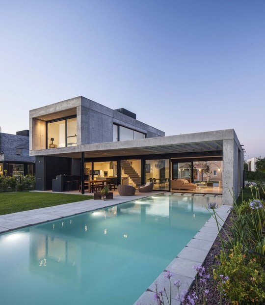 Moderna casa de hormigón visto con ventanales y piscina en exterior — proyecto CASA EH, por GMARQ