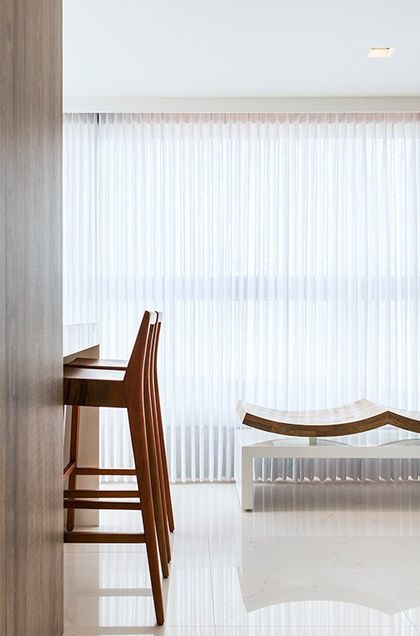 Comedor minimalista con sillas de madera y cortinas verticals blancas — proyecto Apartamento 180m Boa Viagem, por André Caricio