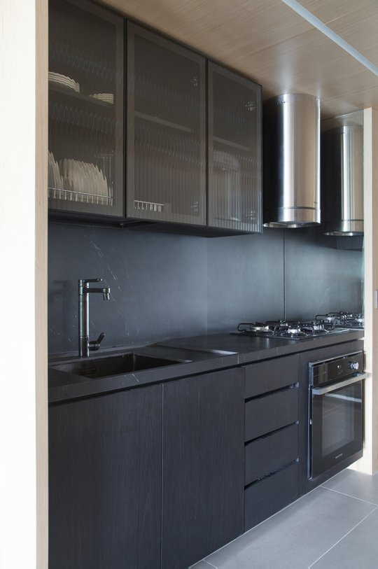 Cocina moderna negra con mesada oscura y alacenas vidriadas — proyecto MN House, por Studio Ro-ca