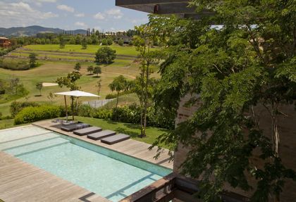 Casa moderna con pileta, deck y vista al campo verde — proyecto Residência MP, por Gil Fialho