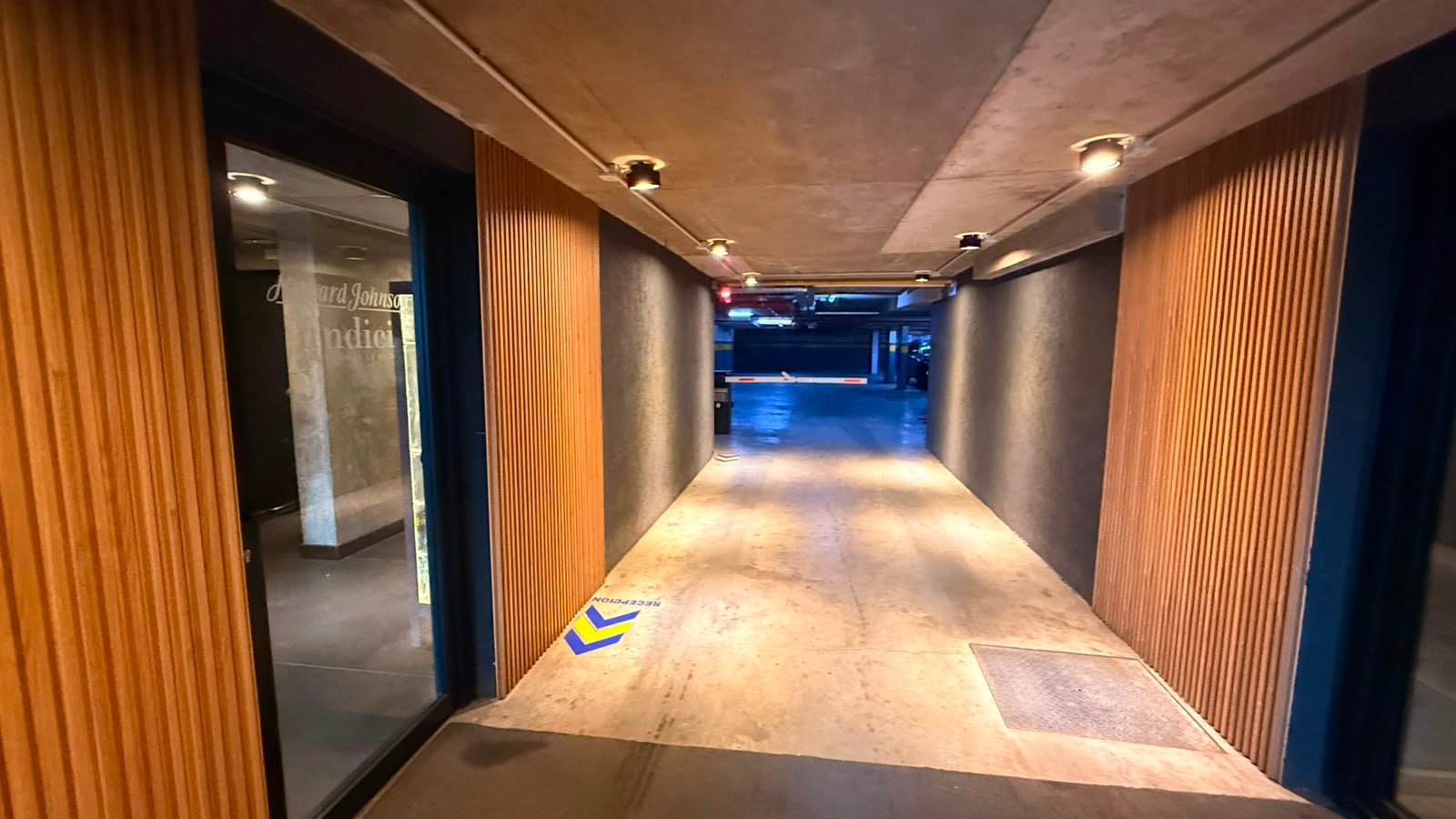 corredor moderno com painéis de madeira e iluminação indireta — projeto UNDICI - Howard Johnson- La Boca, por COMOTTO - SOMMER  - ARQUITECTOS, em Brandsen 927