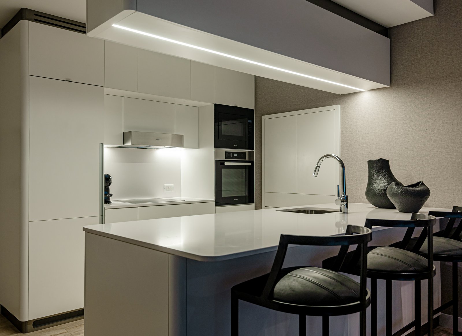 Cocina moderna minimalista con isla grande y luz indirecta — proyecto OBRA OCEANA, PUERTO MADERO, por MARCELO MAZZA, en Puerto Madero