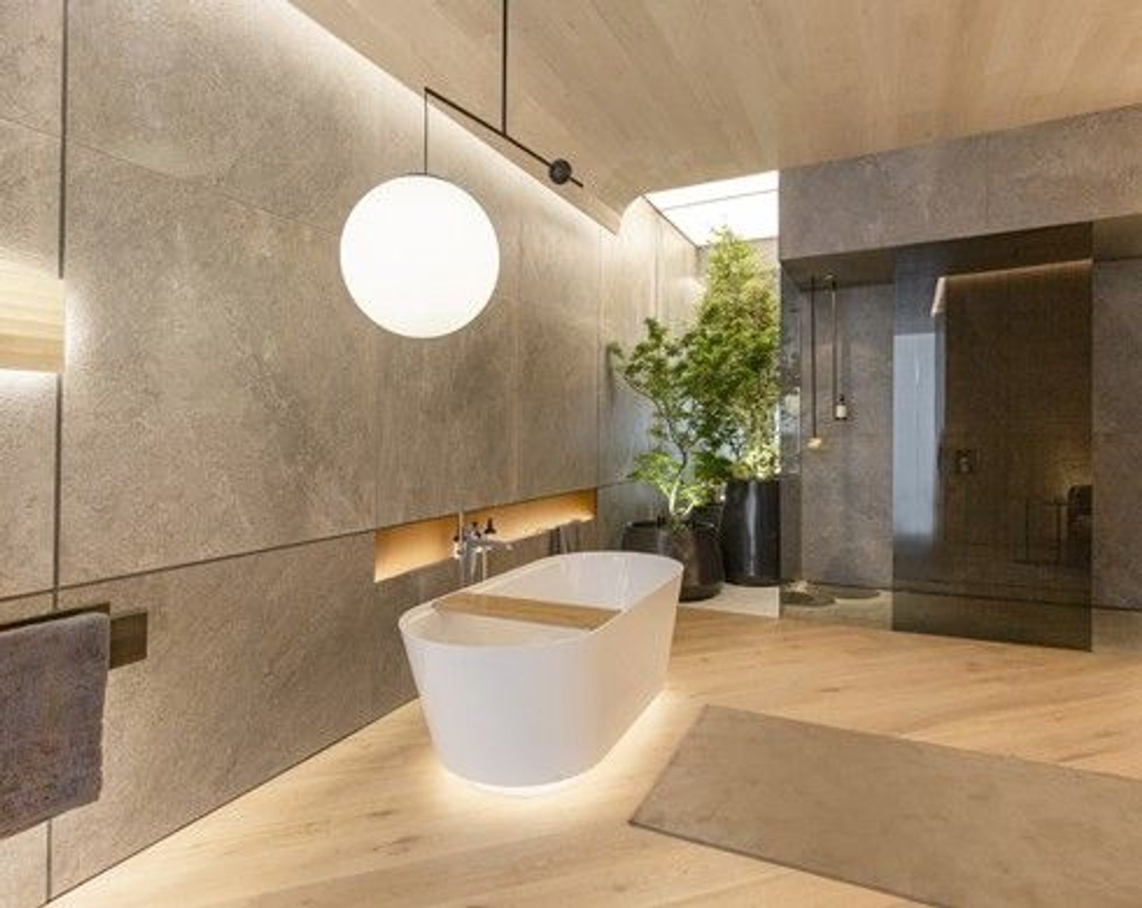 Banheiro moderno com banheira de imersão e paredes de pedra texturizada — projeto Casa Foa Edificio del Plata, por Vite Porcellanato, em Buenos Aires