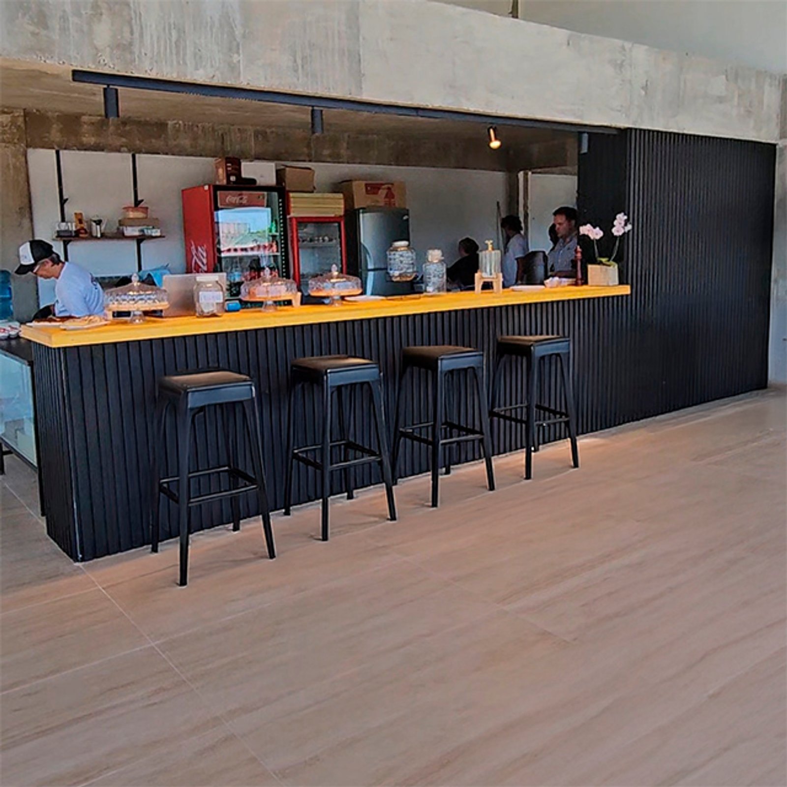 Cafeteria moderna con barra de madera y taburetes industriales — proyecto Revestimiento de Aluminio, por Aluar División Elaborados