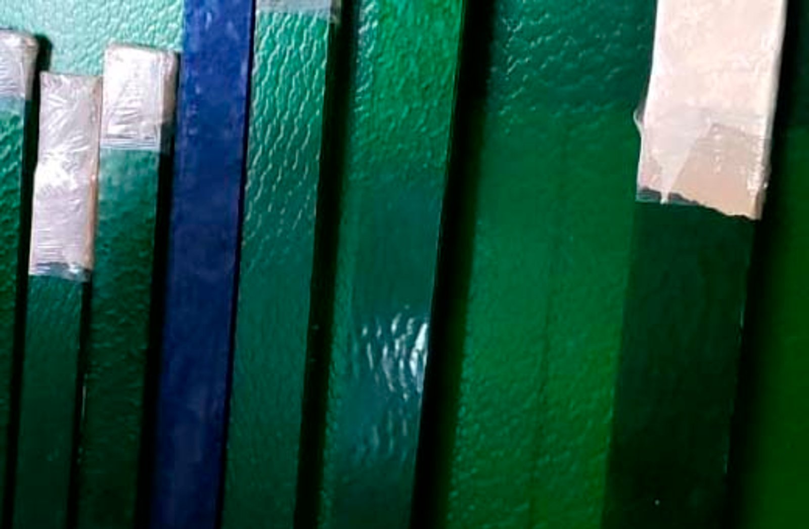 paneles verticales revestidos en verde y azul — proyecto Vidrios repartidos, por Cristalcenter, en Mataderos