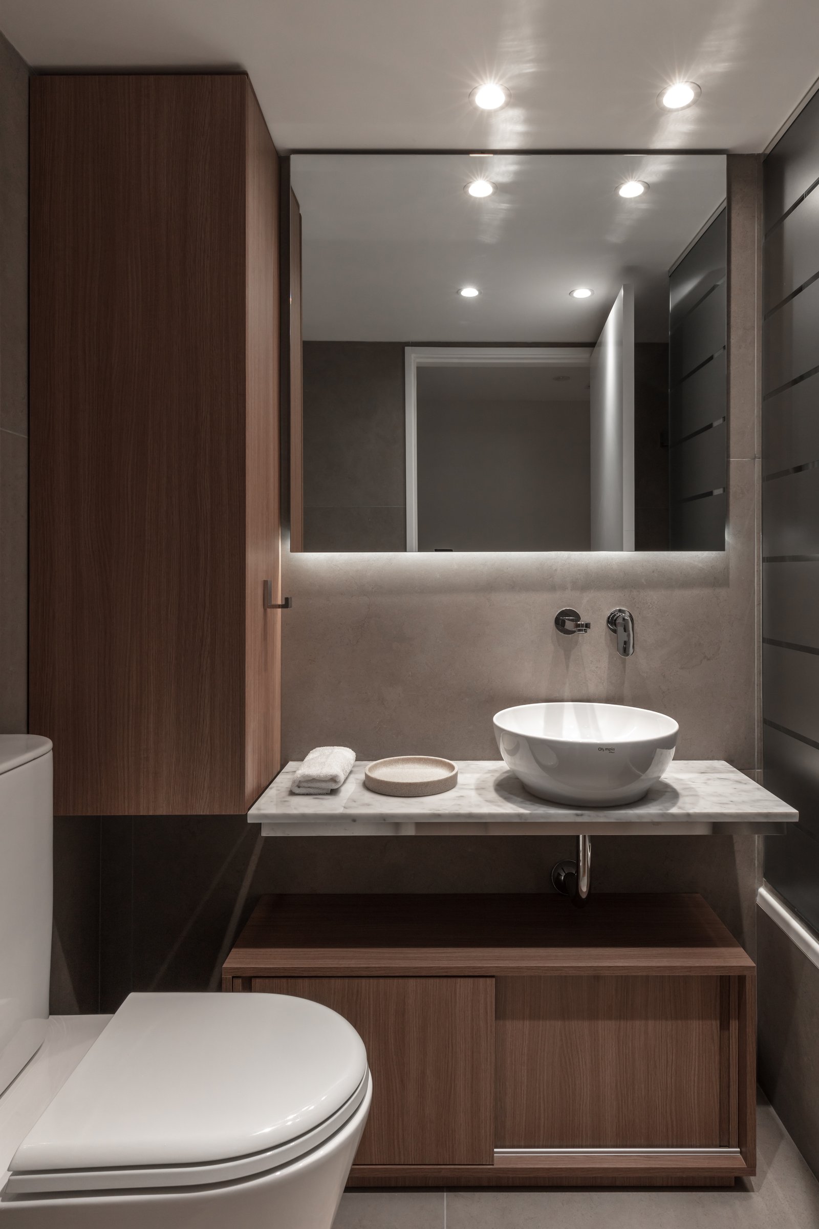Banheiro moderno com gabinete de madeira e espelho iluminado — projeto Donna Fiore | Sobrio & sofisticado | Sober & Sophisticated | Lucia Quinteros, por Ren Studio, em Provincia de