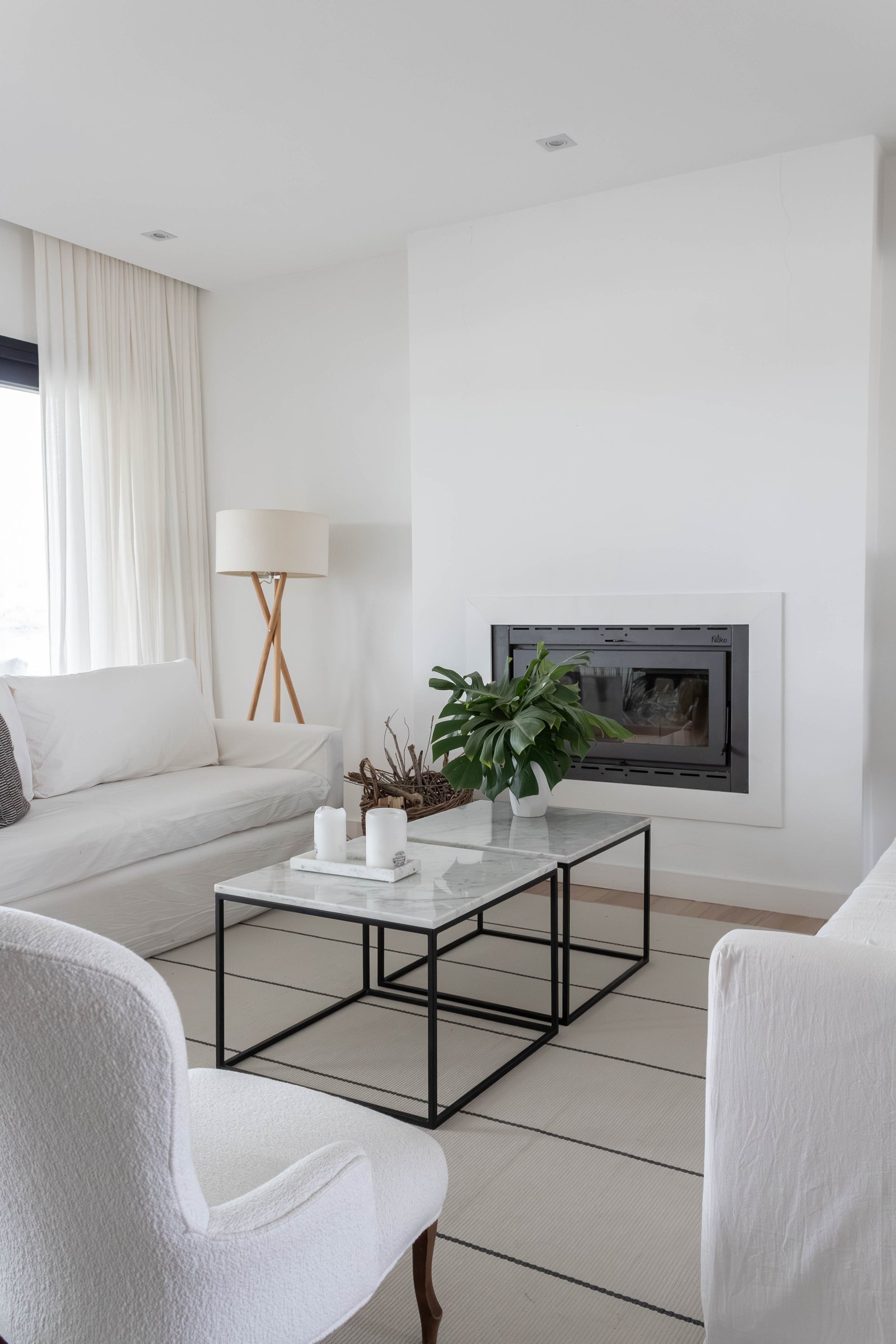 Sala moderna com sofá branco, lareira e mesas de mármore — projeto Santa Ana II, por Catalina Fitero Fotografìa, em Arribeños 1611